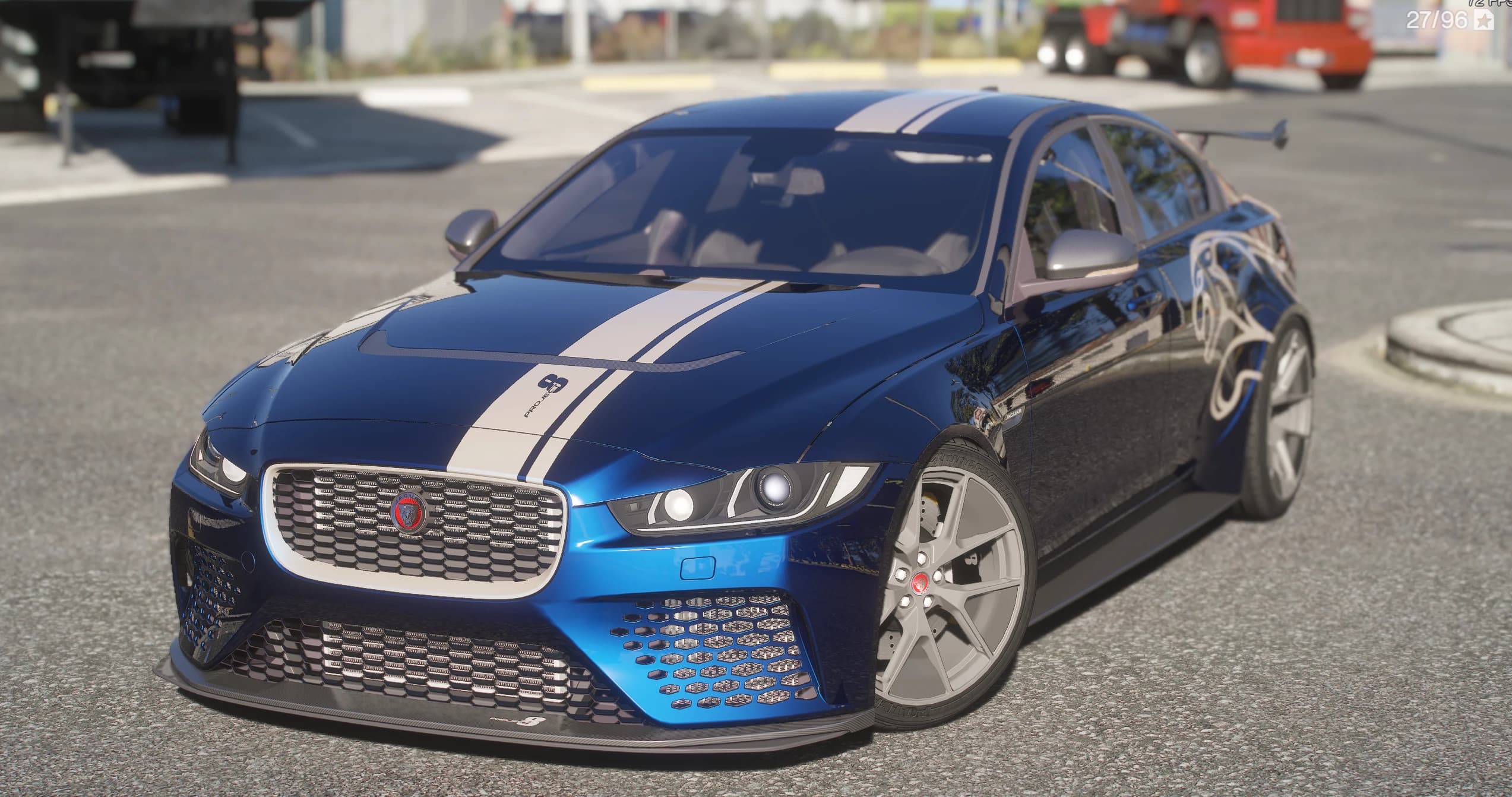 Jaguar XE SV Project 8 2018 en azul metalizado, tres cuartos delantero a plena luz, franja blanca con el adhesivo PROJECT 8 sobre el capó, paragolpes delantero de malla profunda, splitter de carbono y llantas plateadas de cinco radios