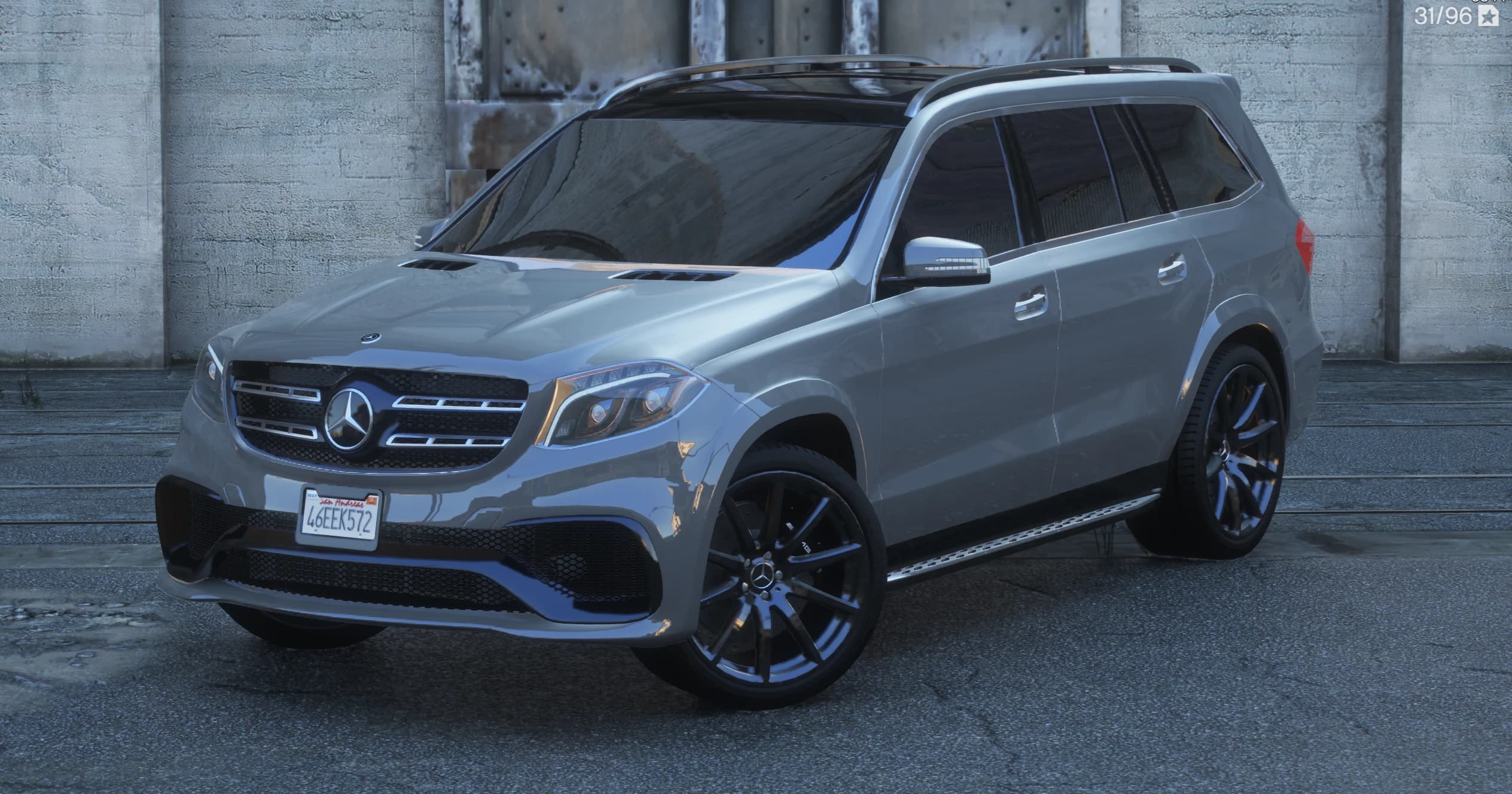 Vista frontal en tres cuartos del GLS 63 AMG plateado con su parrilla de doble lama, las tomas de aire del capó y llantas AMG negras multirradio