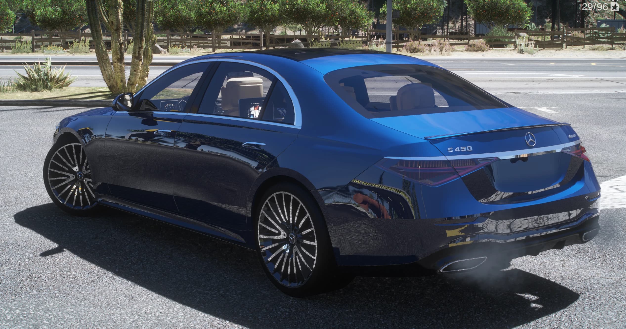 Tres cuartos trasero del S450 azul con las insignias S 450 y 4MATIC, la estrella de Mercedes y los pilotos LED conectados
