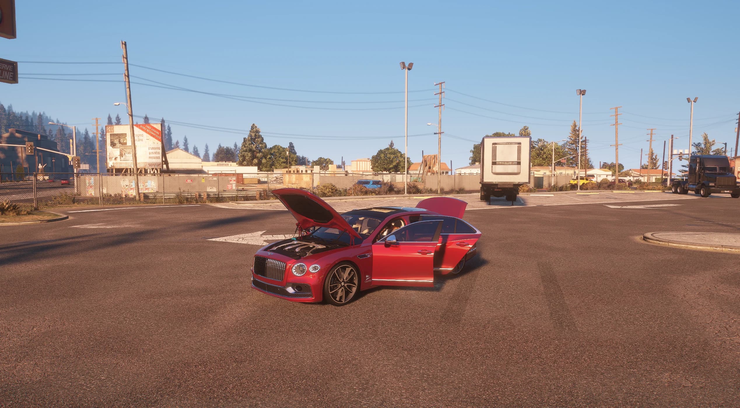 El Flying Spur rojo parado en un cruce amplio bajo un cielo despejado con el capó y las dos puertas del lado derecho abiertos, mostrando el vano motor y la cabina de cuero crema