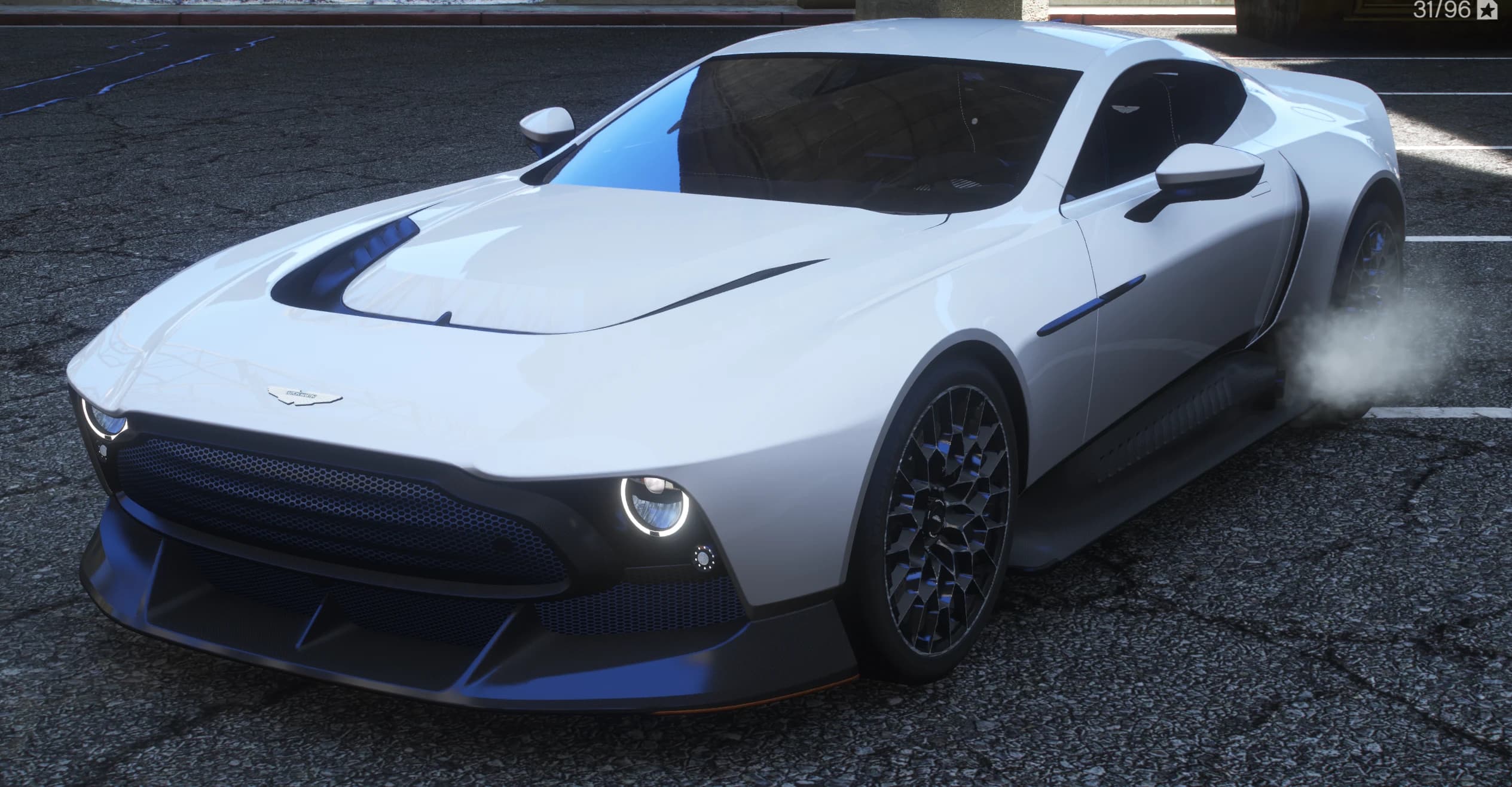 Vista frontal en tres cuartos del Aston Martin Victor blanco perla con faros LED redondos, la enorme parrilla oscura y llantas de celosía