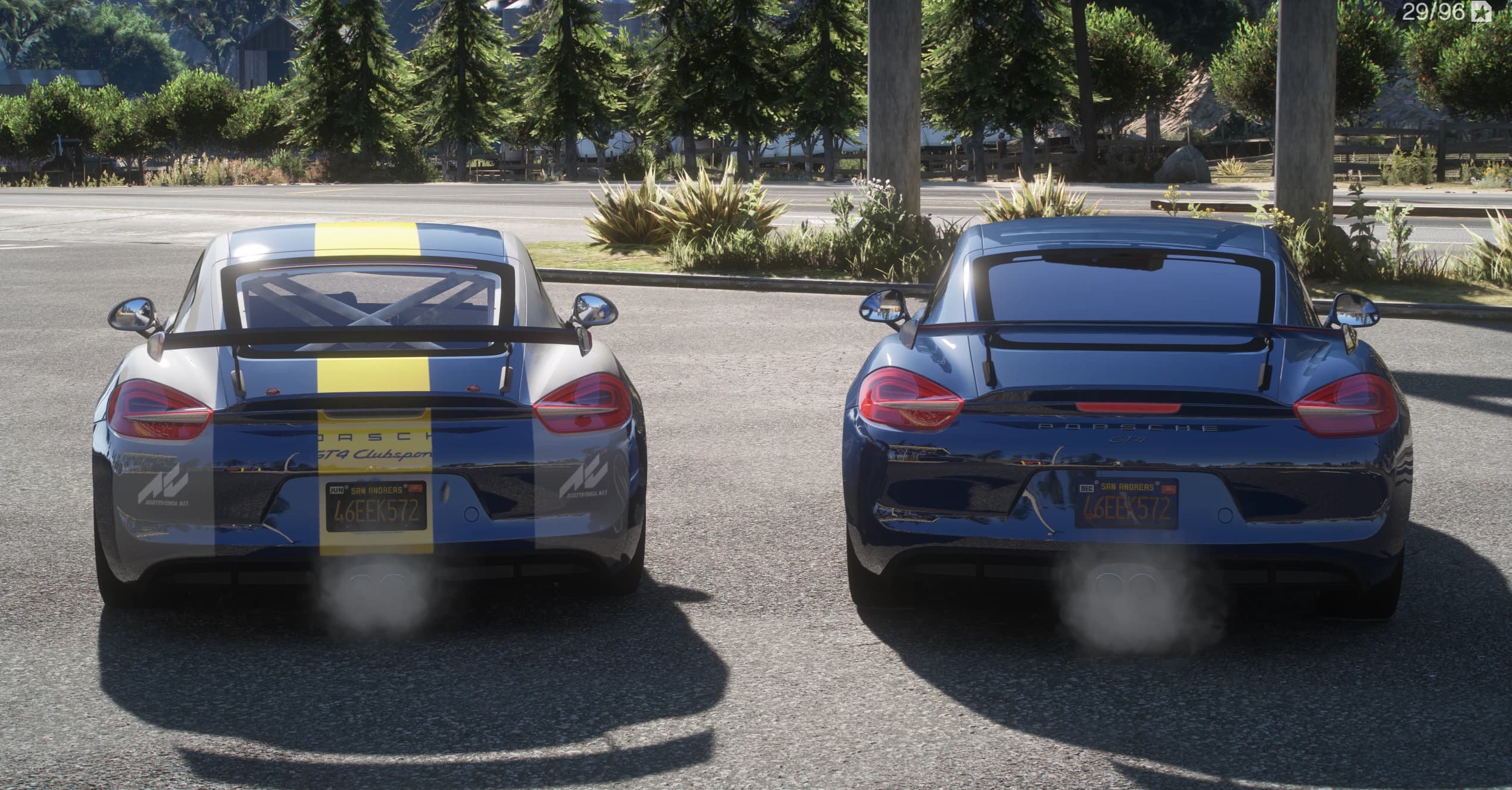 Vista trasera de los dos Cayman, el GT4 Clubsport con franja amarilla de competición y calcas GT4 Clubsport, y el GT4 de calle en azul oscuro con alerón fijo