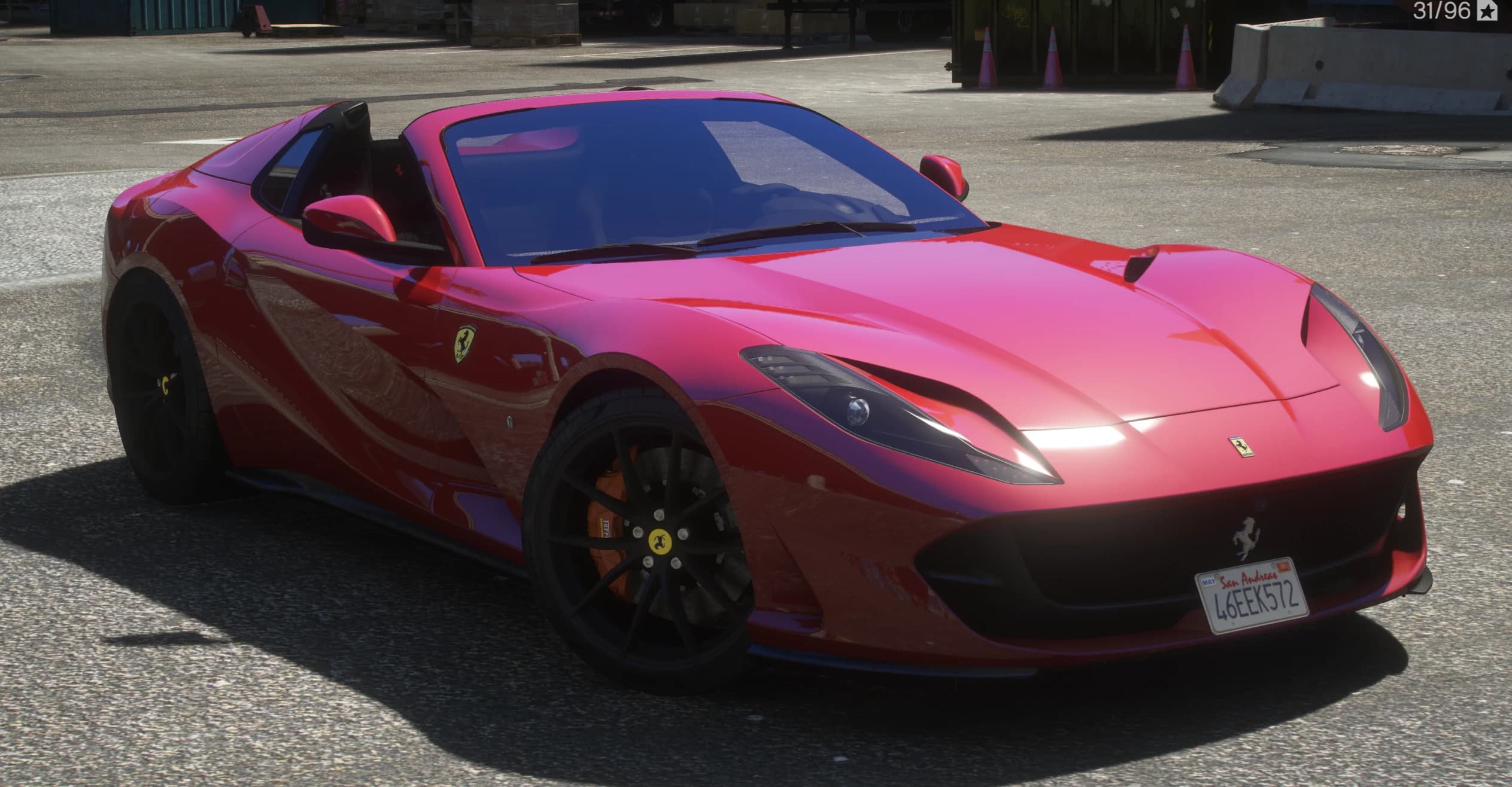 Vista frontal en tres cuartos del Ferrari 812 GTS rojo descapotado, con llantas negras, pinzas naranjas y matrícula de San Andreas