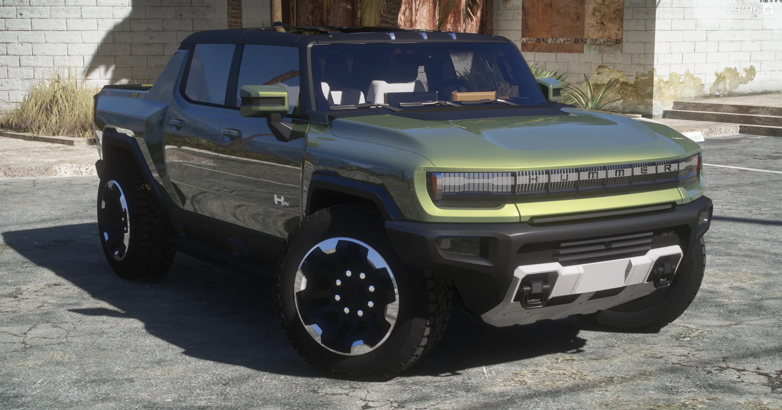 Tres cuartos frontal cercano del Hummer EV con la parrilla HUMMER iluminada, la cabina descubierta y los asientos blancos