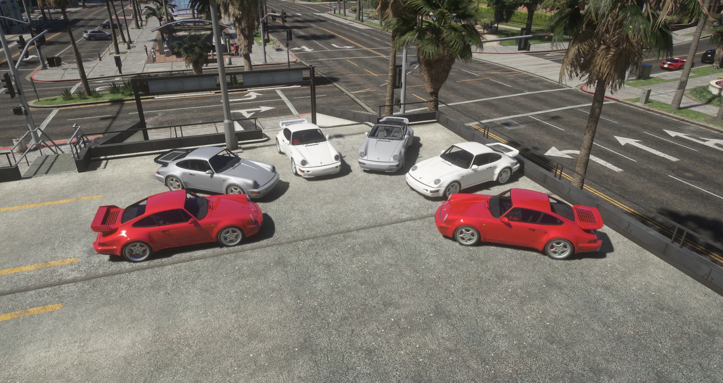 El pack 964 al completo alineado en un aparcamiento junto a un cruce urbano, con los Turbo de cola de ballena al lado de los coches de carrocería estrecha y el Speedster de parabrisas recortado