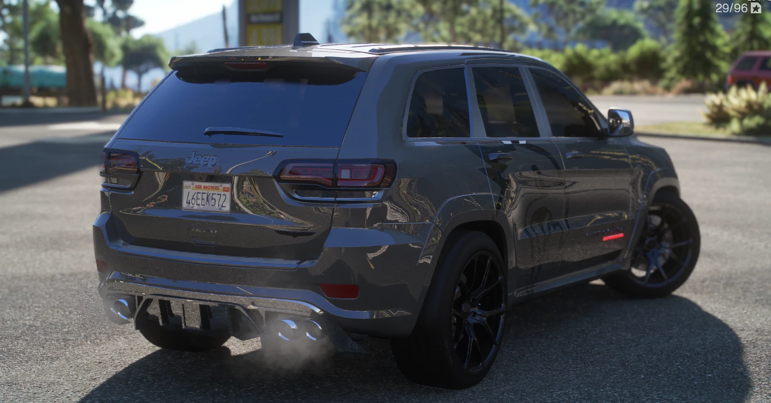 Tres cuartos trasero del Trackhawk plateado con las insignias Jeep y Grand Cherokee, el escape cuádruple y el gráfico lateral del león