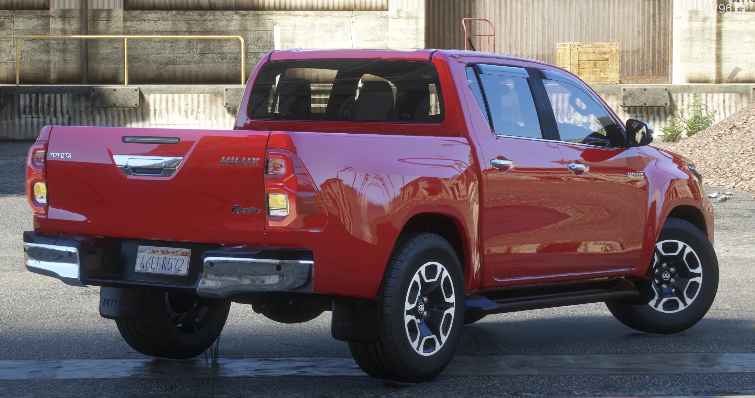 Vista trasera en tres cuartos con el portón con letras Toyota y tirador cromado, los emblemas Hilux y Revo, el paragolpes cromado y las faldillas Hilux