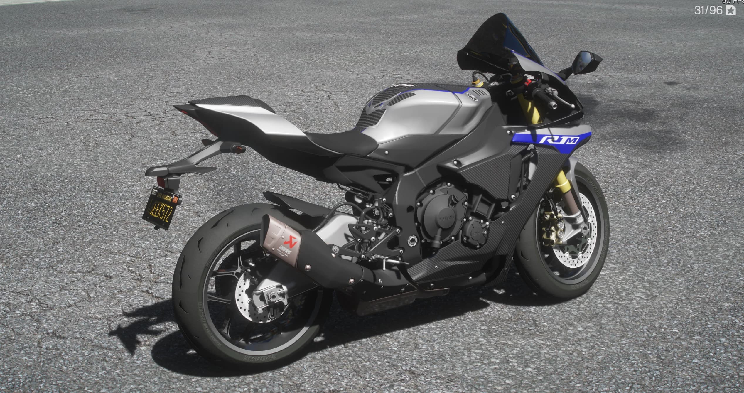 Vista trasera en tres cuartos del R1M con el silencioso Akrapovic de titanio, la matrícula negra de San Andreas y los paneles de carbono sobre el depósito