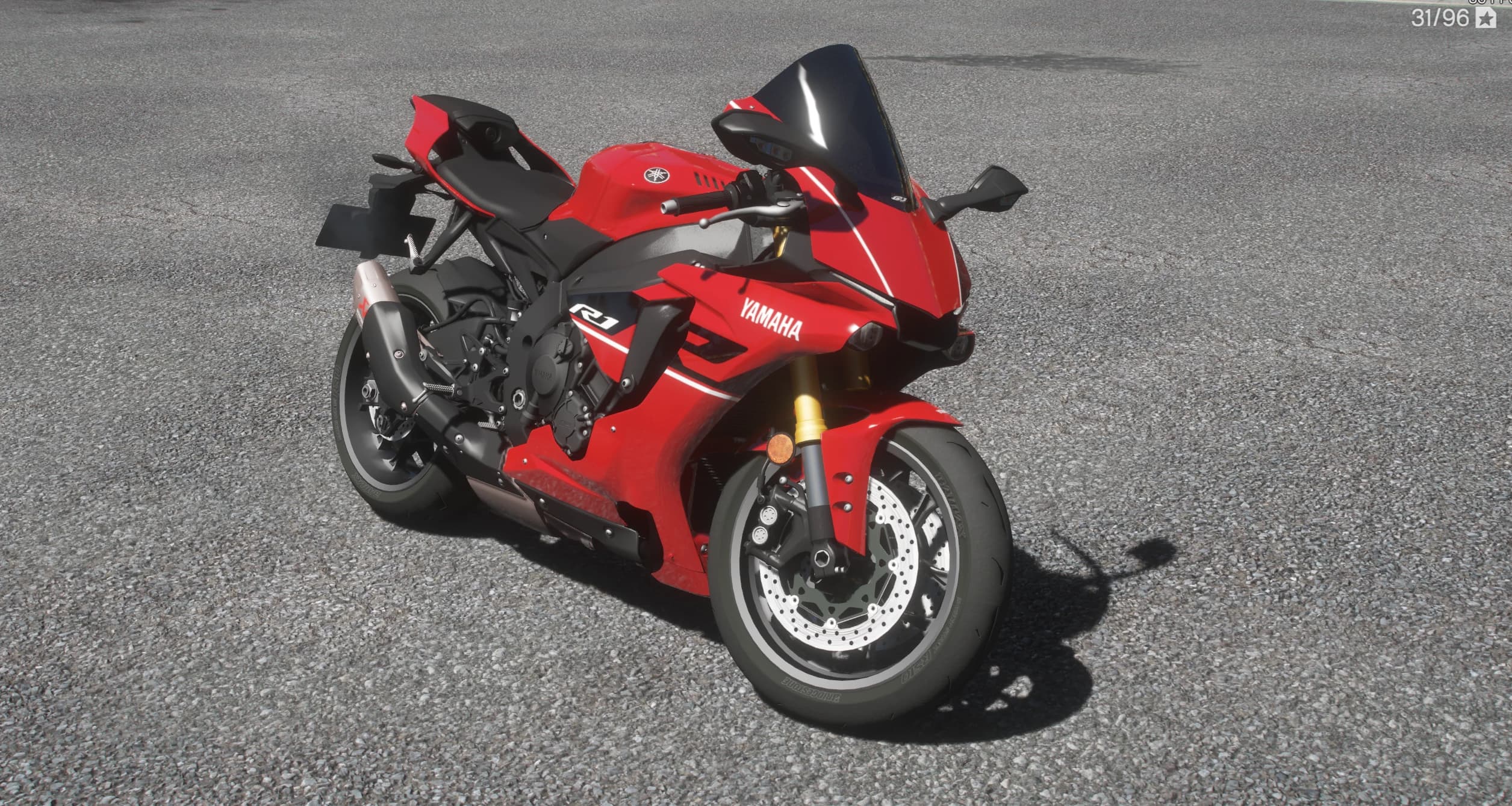 Vista frontal en tres cuartos de la R1 roja con el logo Yamaha en el carenado, cúpula ahumada, horquillas doradas y doble disco de freno delantero perforado
