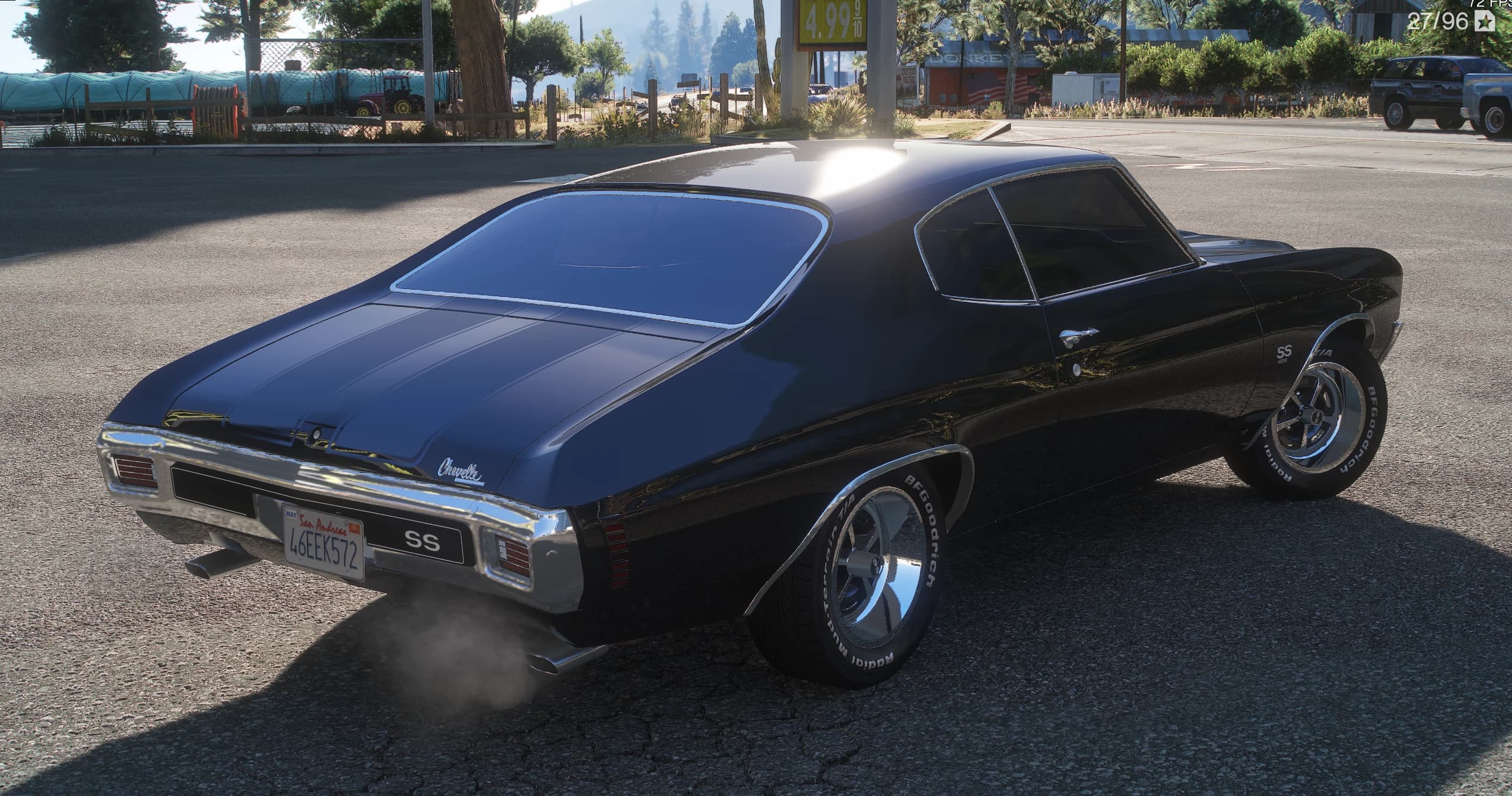 Tres cuartos trasero del Chevelle negro en una gasolinera, con el logotipo Chevelle en la tapa del maletero, la insignia SS entre los pilotos y humo saliendo del doble escape