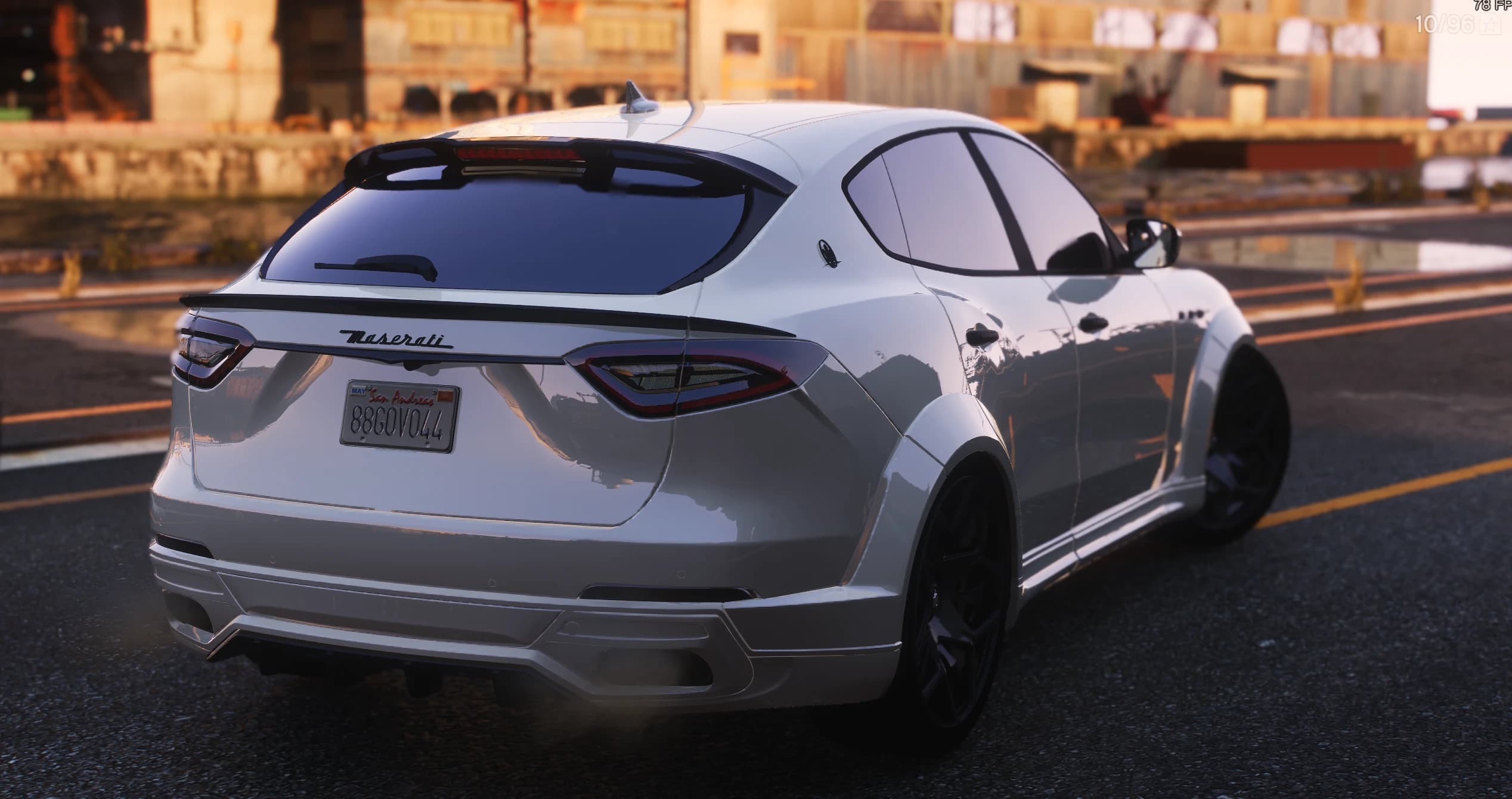 Tres cuartos trasero del Levante blanco al atardecer, con el alerón de techo, el labio negro del portón, el rótulo Maserati y la matrícula de San Andreas 88GOV044