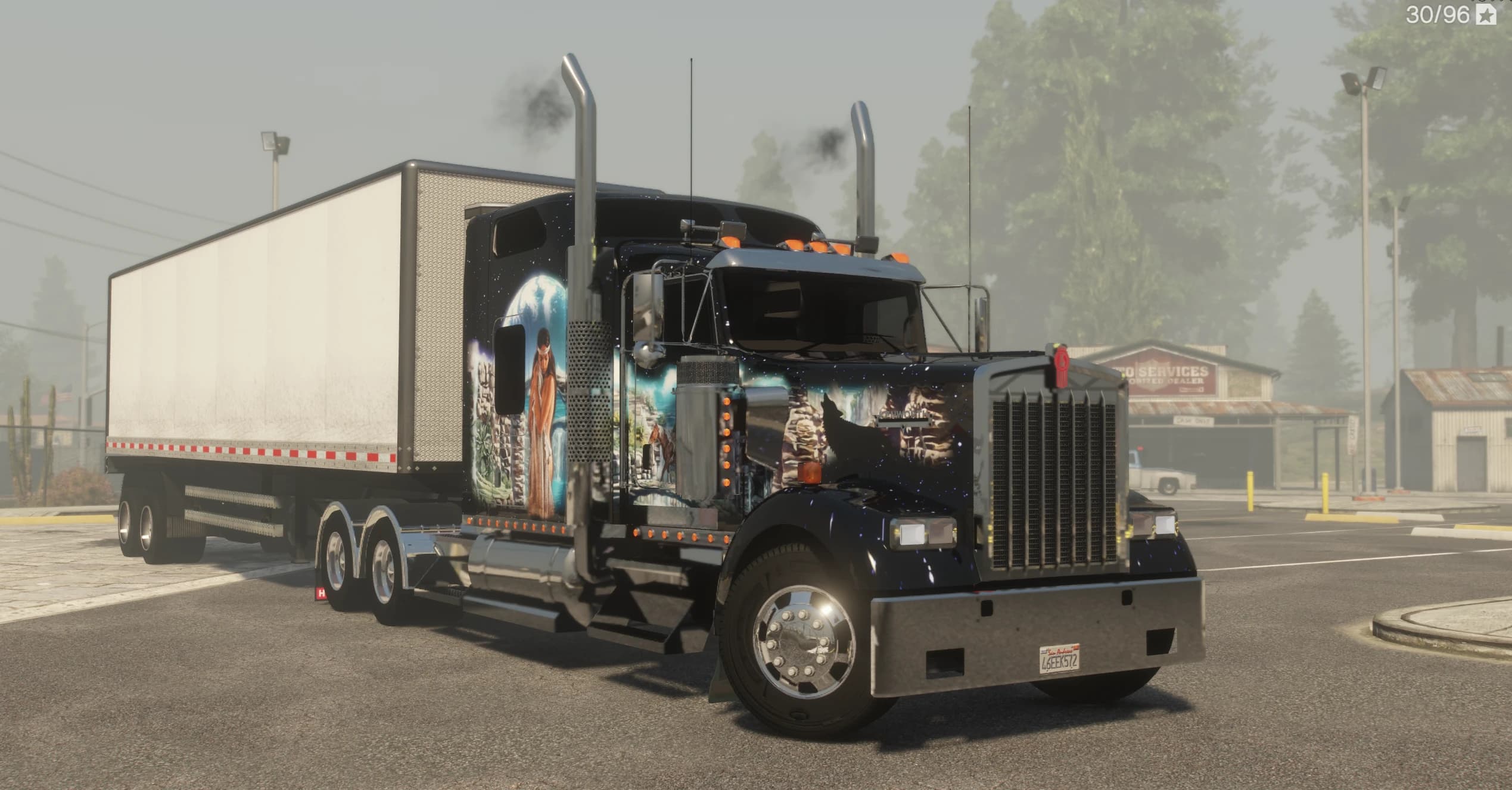 El W900 aparcado con su tráiler, con el lobo aullando aerografiado sobre el capó y una mujer nativa americana pintada en la cabina dormitorio