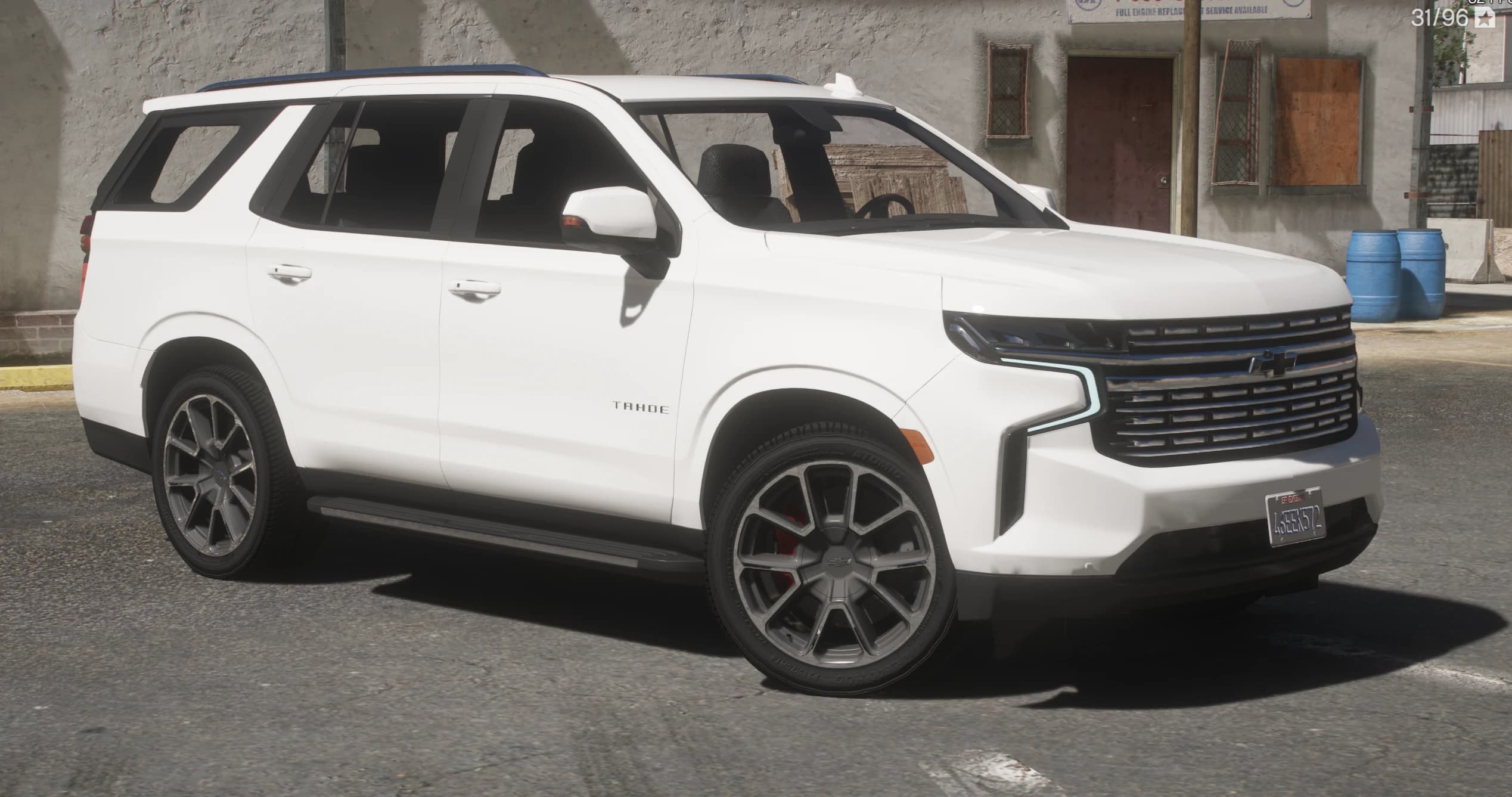 Vista frontal en tres cuartos del Chevrolet Tahoe RST blanco con las tiras de luz diurna encendidas, la calandra ancha y llantas mecanizadas en dos tonos sobre pinzas rojas