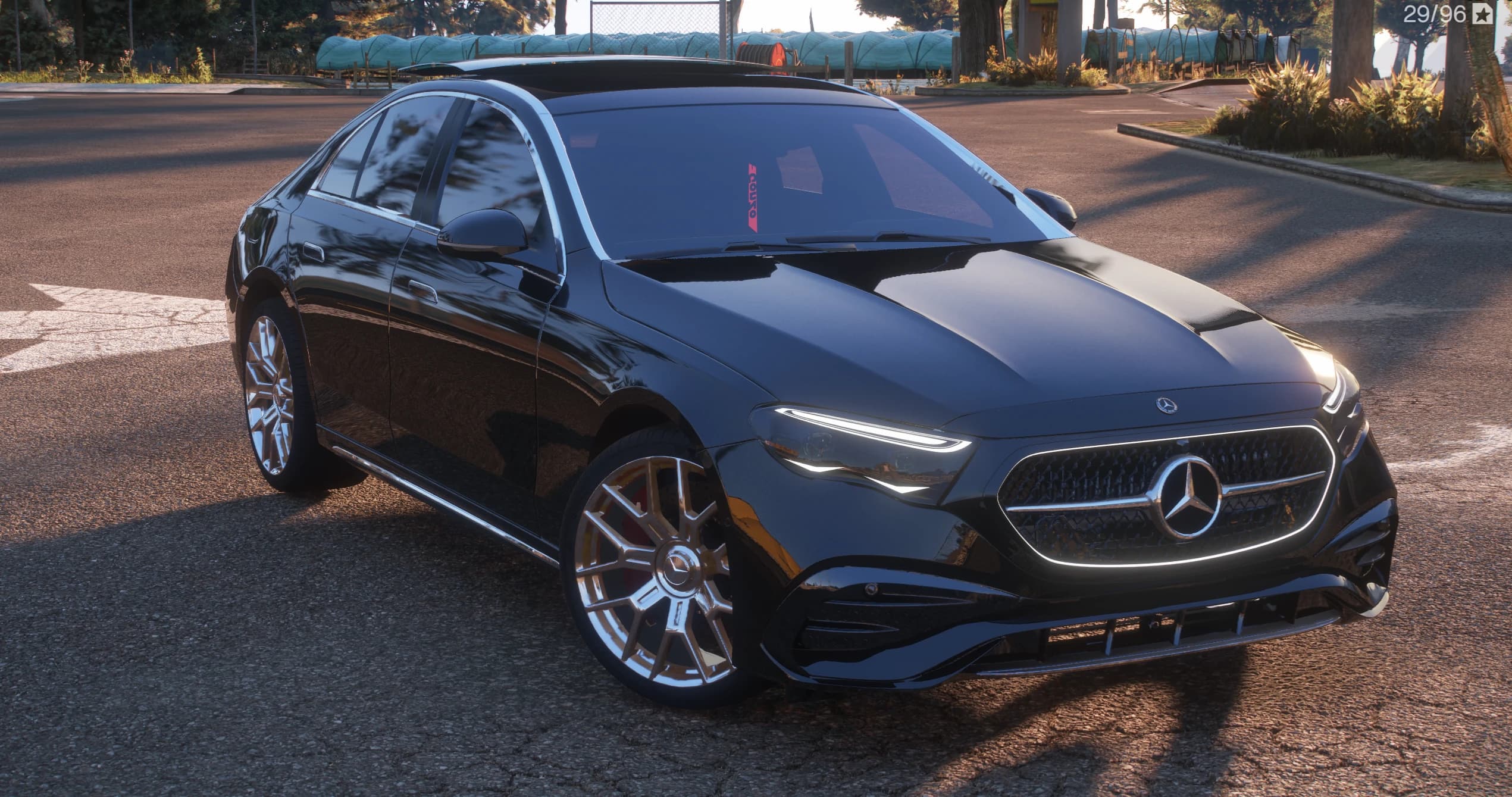Mercedes-Benz E350 de 2025 en negro, tres cuartos frontal con la parrilla de estrella iluminada y llantas multirradio, aparcado en un cruce