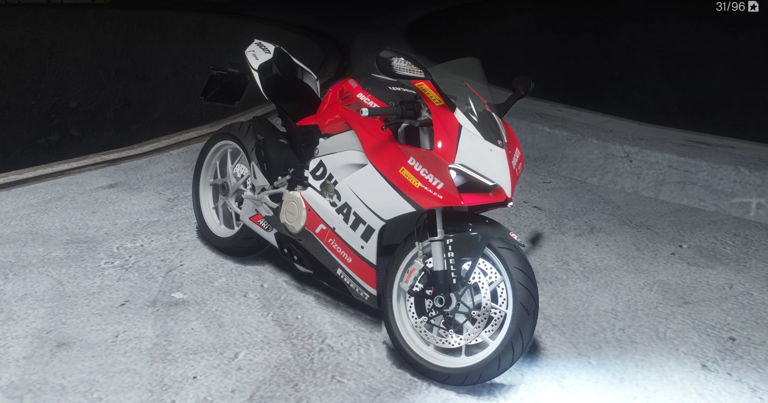 Vista frontal en tres cuartos de la Panigale V4 con decoración de patrocinadores roja y blanca, llantas blancas, pinzas Brembo y protector Pirelli en la horquilla