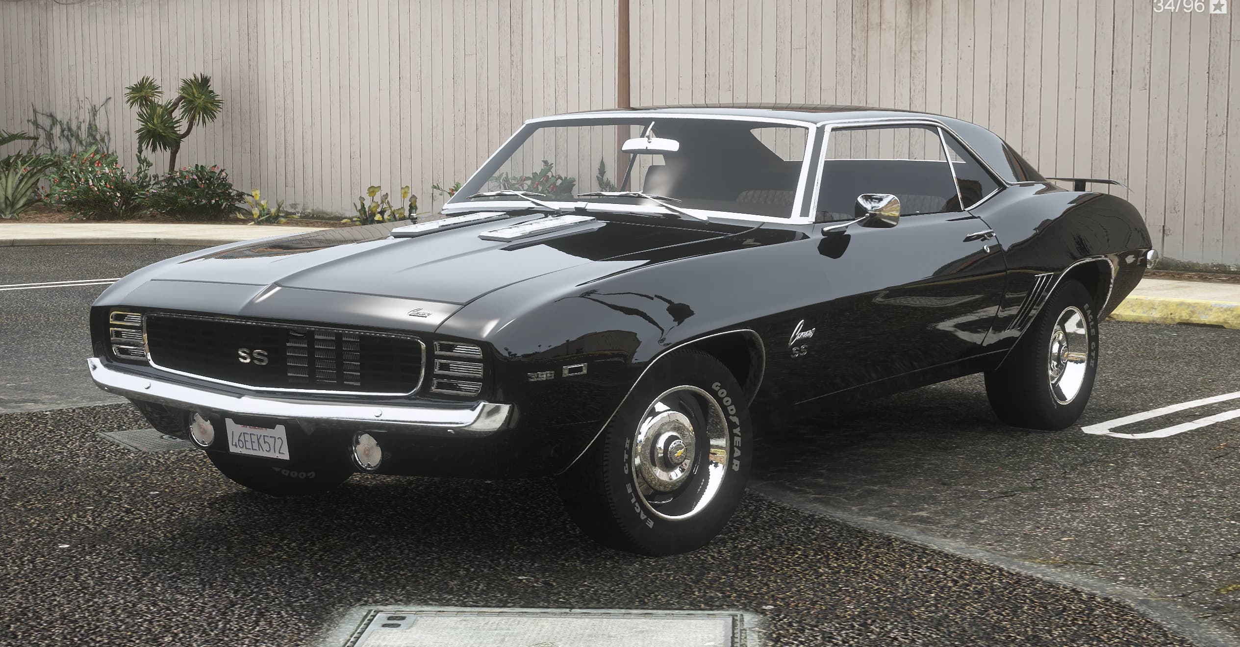 Vista frontal en tres cuartos del Camaro SS de 1969 negro con el emblema SS en la parrilla, parachoques cromado y neumáticos Goodyear de letras blancas