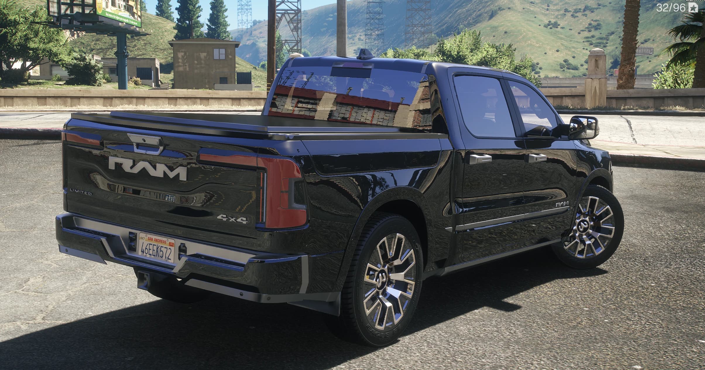Vista trasera en tres cuartos de la pickup con las letras RAM en el portón, los distintivos Limited y 4x4 y la cubierta de caja puesta