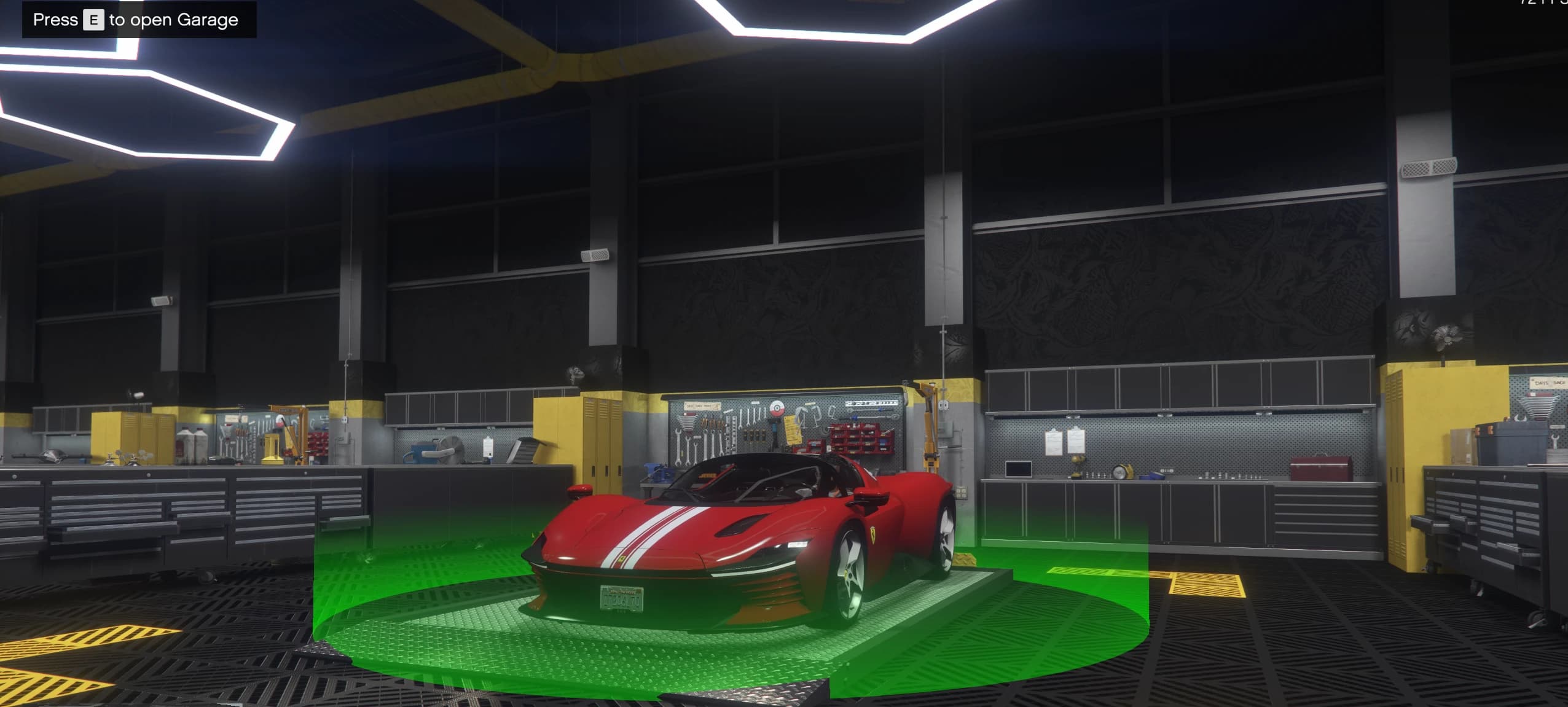 Un superdeportivo rojo aparcado sobre la zona verde del garaje seguro dentro de un taller, con el aviso de pulsar E para abrir el garaje