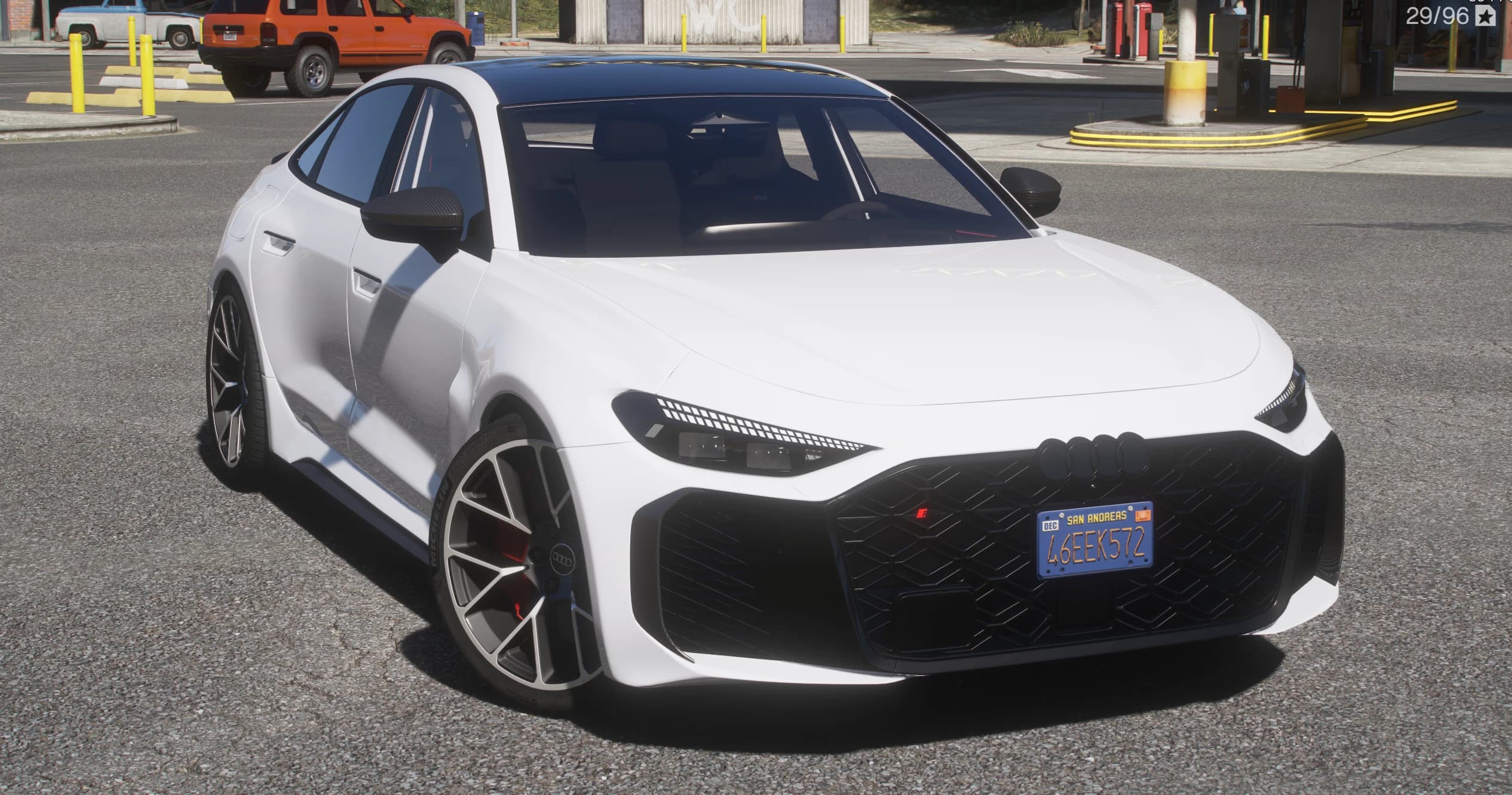 Audi RS5 Sportback de 2026 en blanco, tres cuartos frontal con la amplia parrilla de nido de abeja, los cuatro aros y llantas de cinco brazos con pinzas rojas