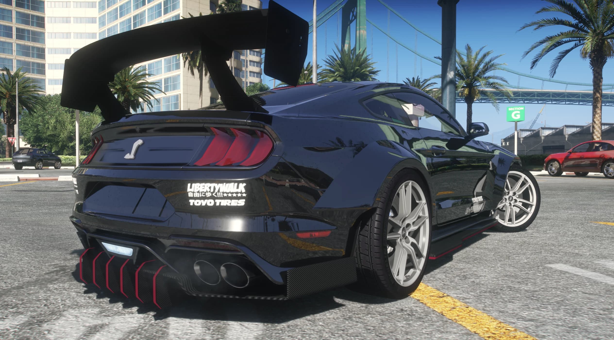 Vista trasera en tres cuartos con el alerón de cuello de cisne, las pegatinas LIBERTYWALK y TOYO TIRES, la cobra en el maletero y las aletas del difusor perfiladas en rojo