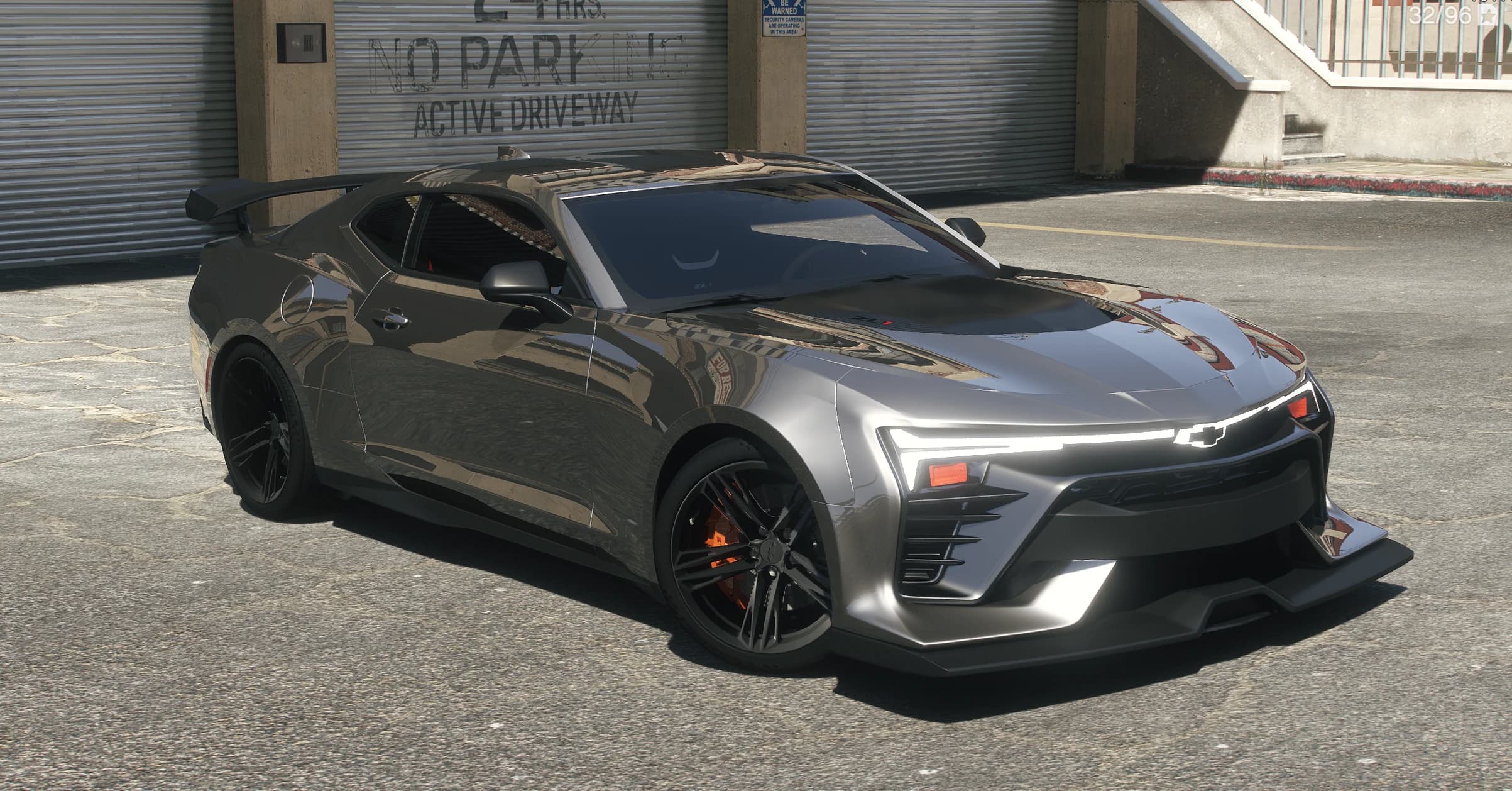 Vista frontal en tres cuartos del Camaro ZL1 gris plomo con la tira LED de lado a lado, la corbata de Chevrolet y pinzas de freno naranjas