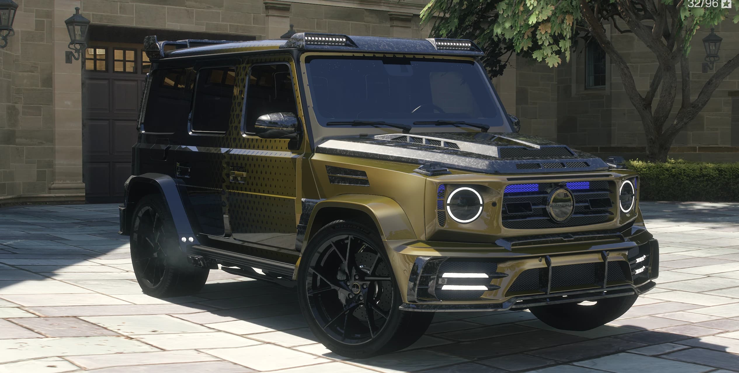 Vista frontal en tres cuartos del Mansory G63 en dorado oliva y negro con el patrón degradado y piezas de carbono forjado