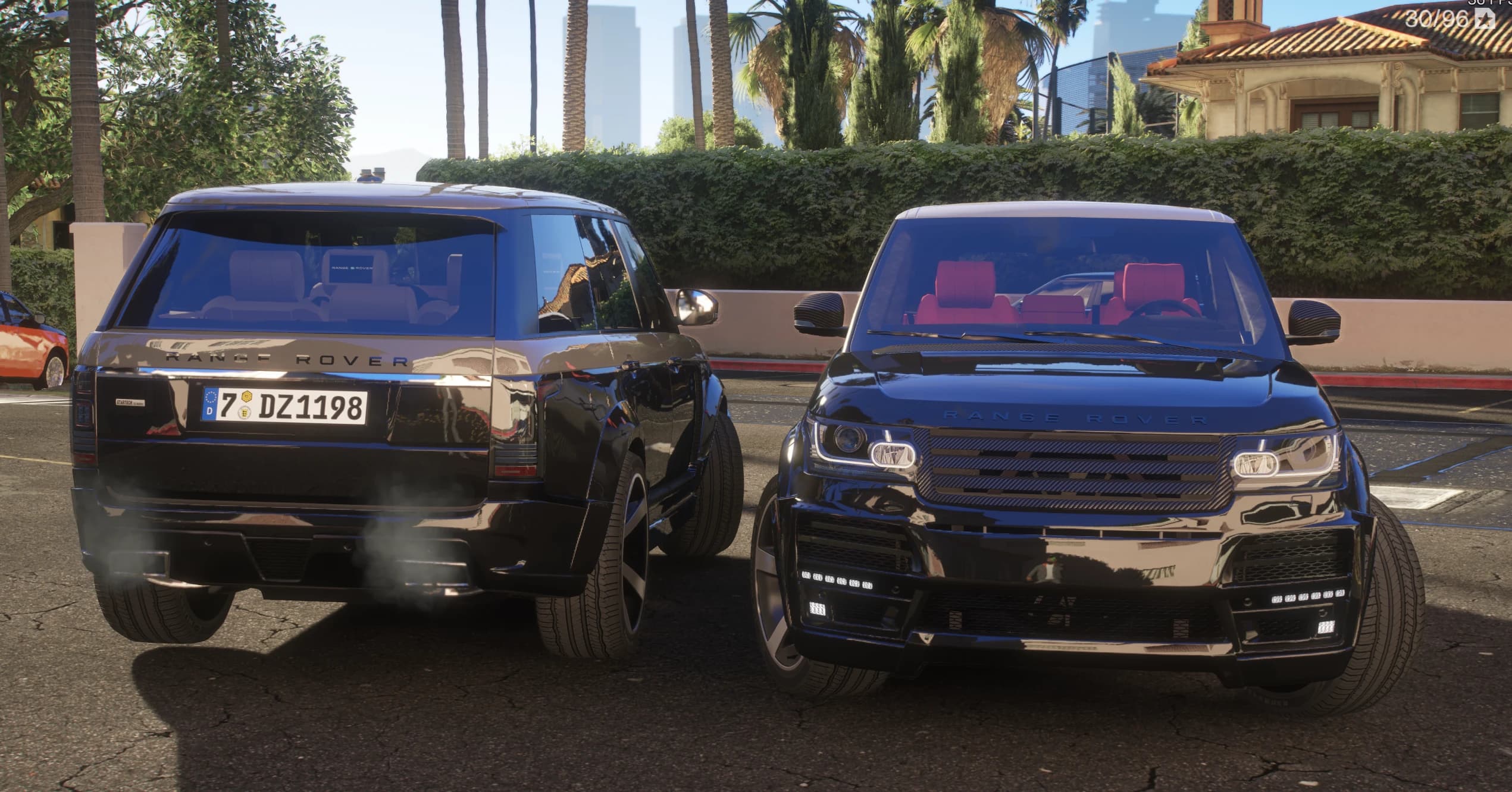 Los dos Range Rover frente a frente bajo las palmeras, uno enseñando la matrícula europea y el otro su interior de cuero rojo