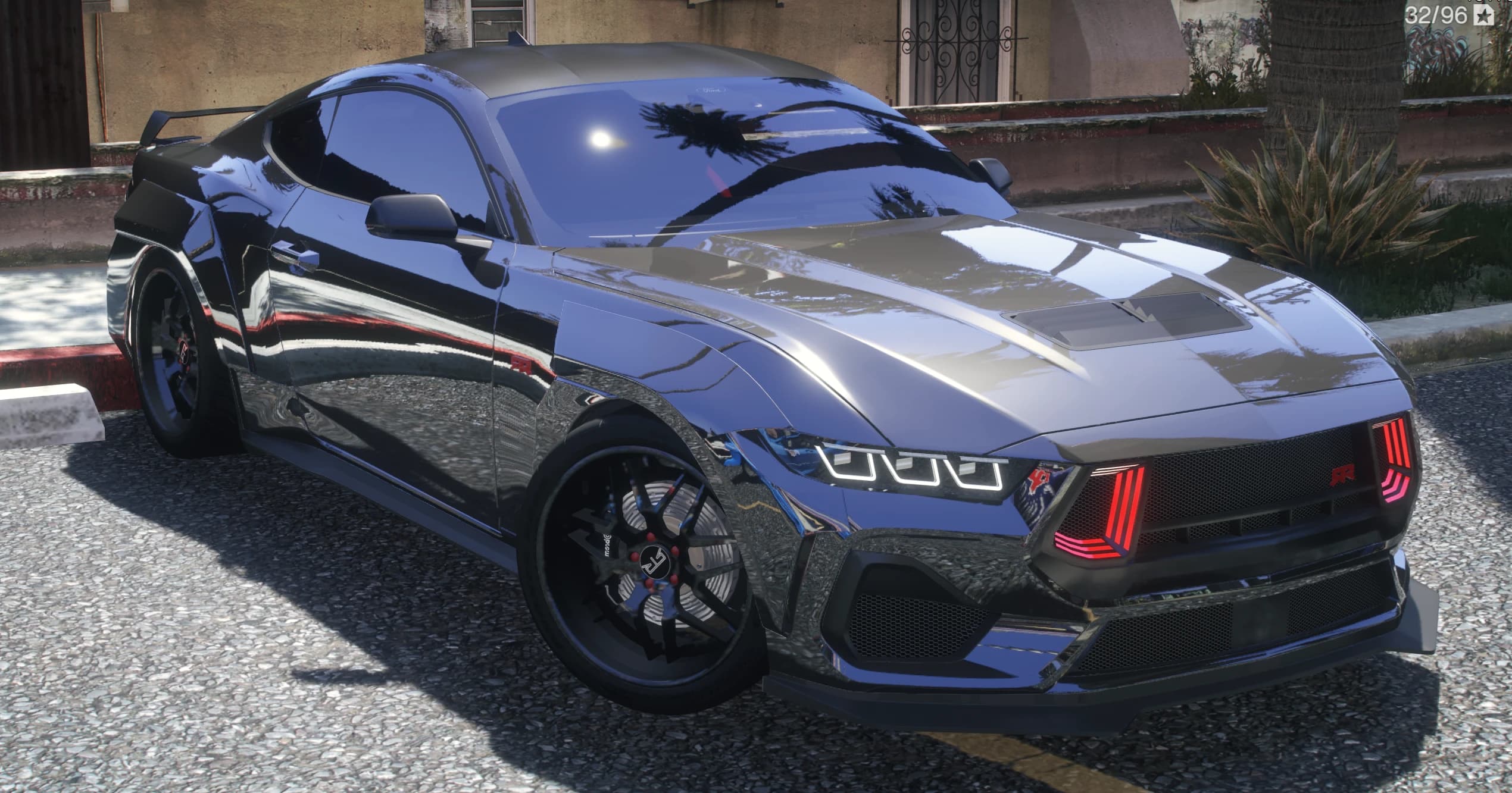 Vista frontal en tres cuartos del Mustang RTR grafito con la parrilla RTR de luces rojas, tomas en el capó y aletines widebody
