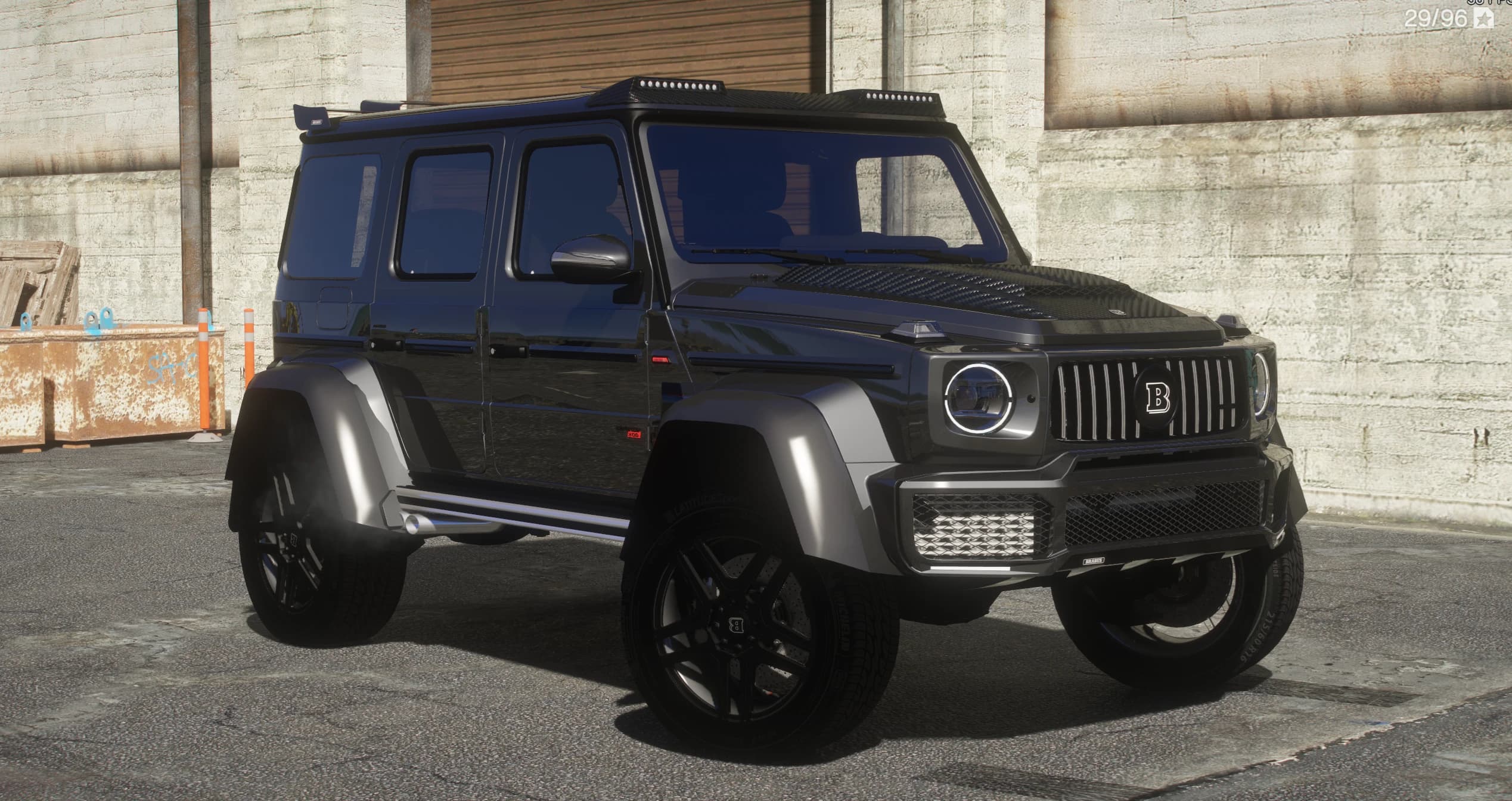 Mercedes G800 Brabus 4x4 negro con capó de carbono, pasos de rueda ensanchados plateados y llantas Brabus negras, tres cuartos frontal frente a una nave industrial