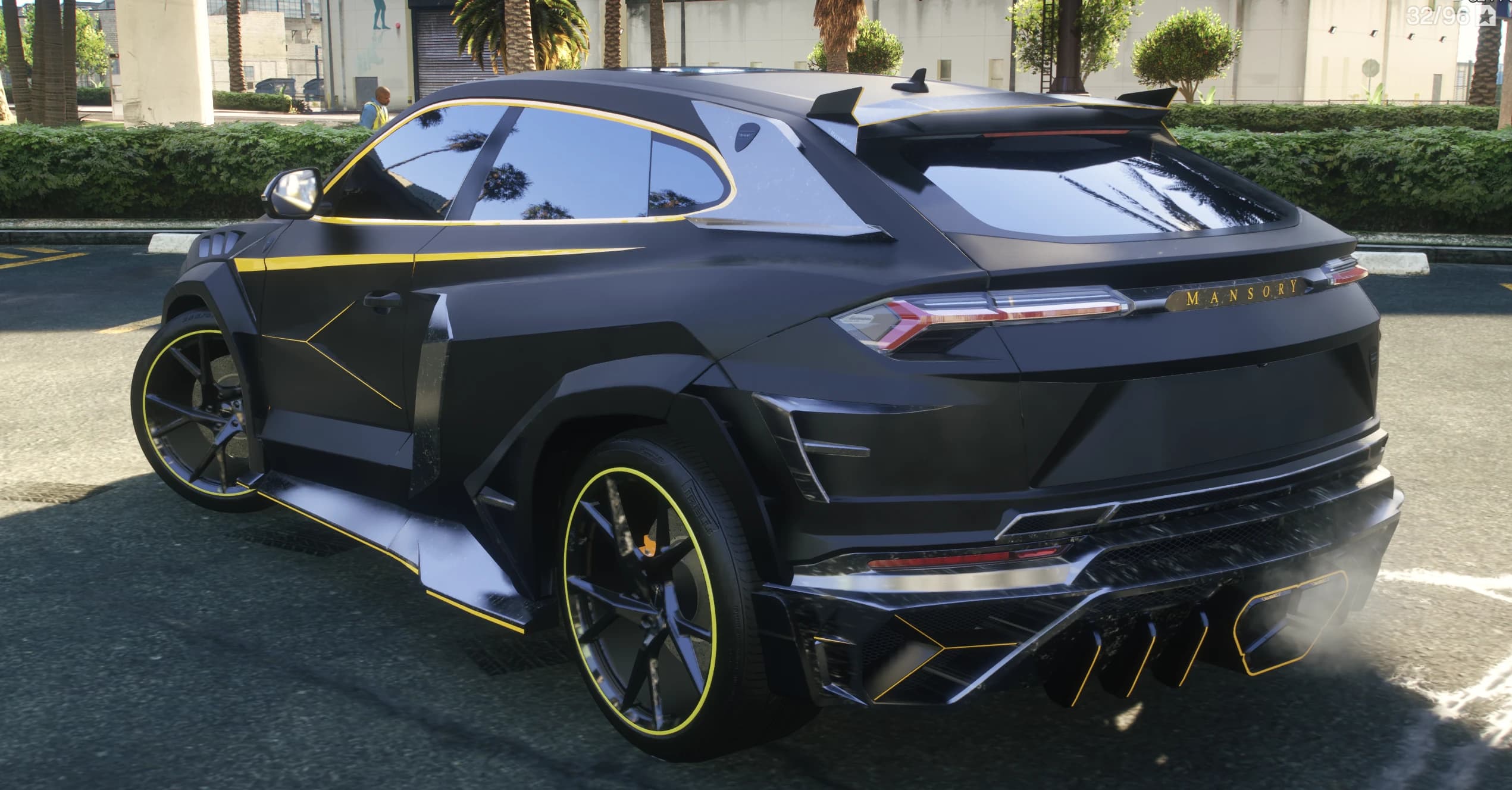Vista trasera en tres cuartos del coupé con las letras MANSORY en el portón, alerón de techo y difusor perfilado en amarillo