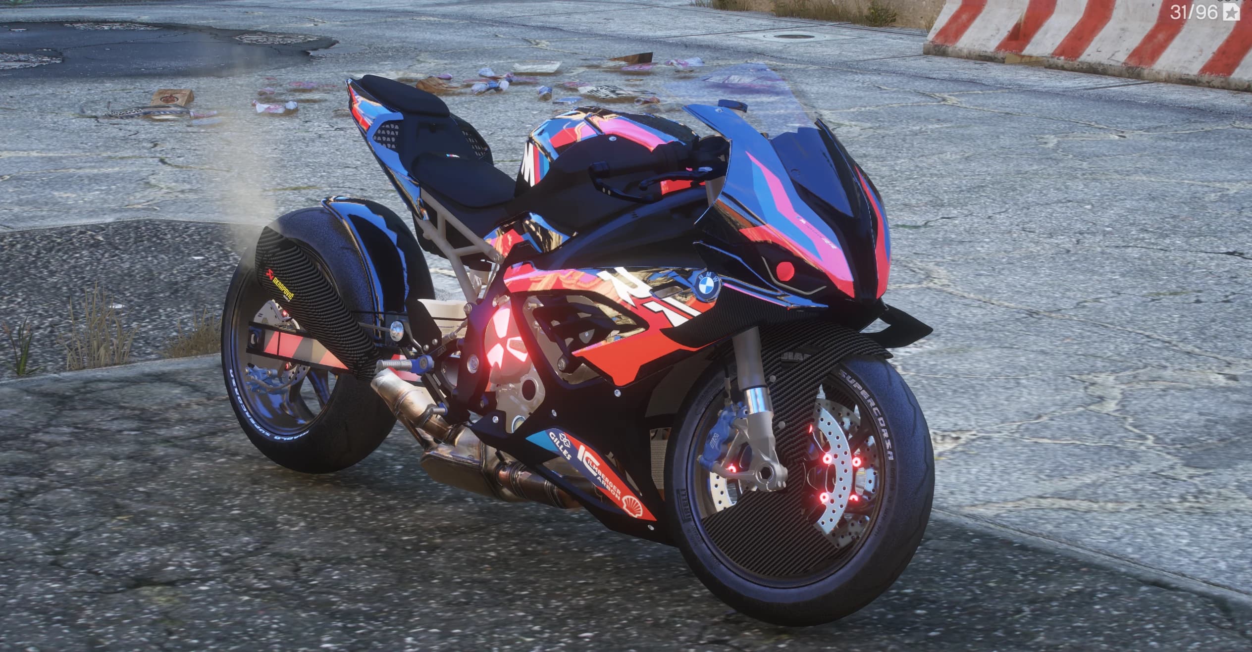 Vista frontal en tres cuartos de la M1000RR estirada con vinilo cromado azul, rosa y rojo, un emblema rojo brillante en el motor y llantas de carbono