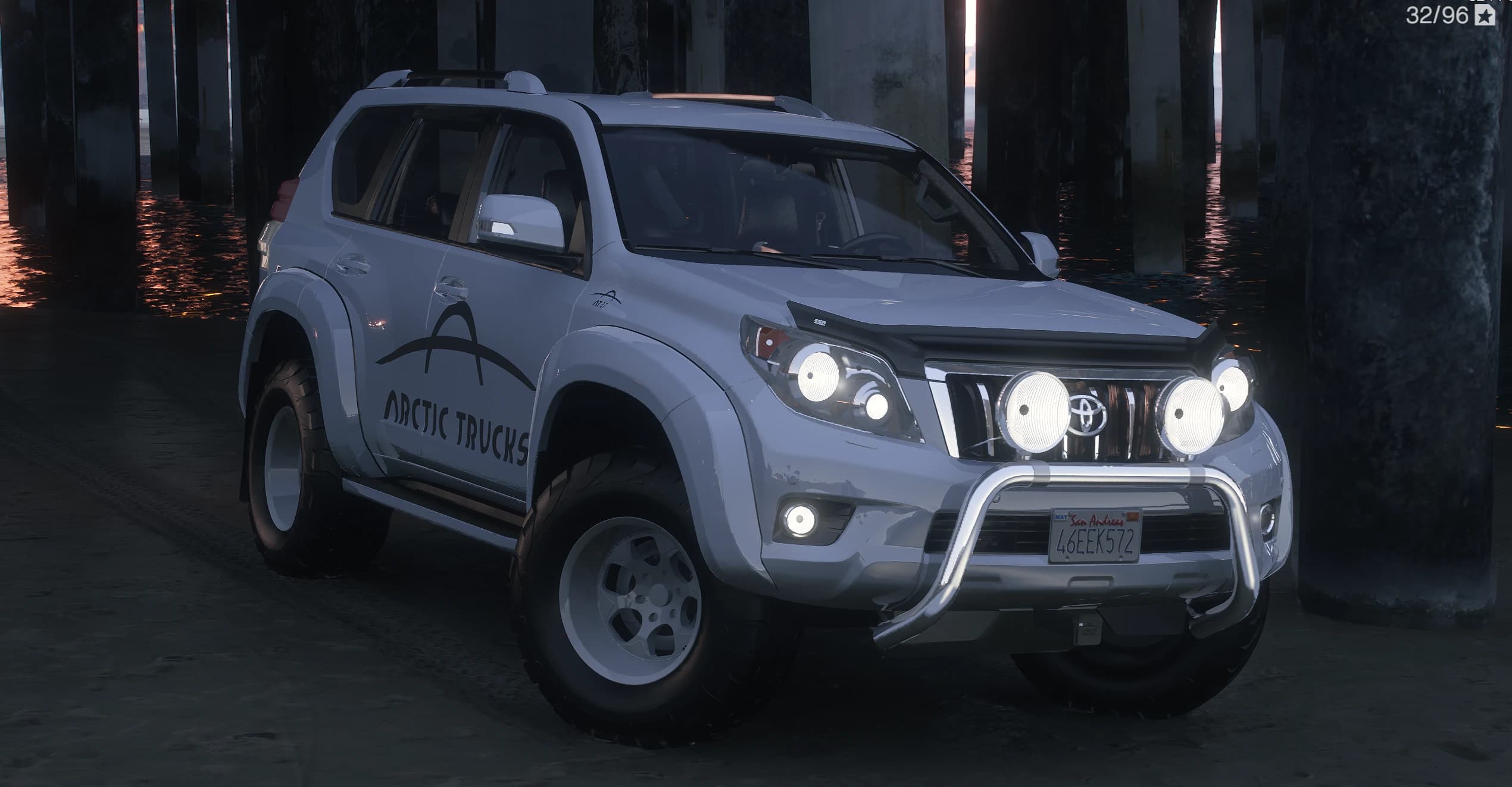 Vista frontal en tres cuartos del Land Cruiser Prado blanco con defensa delantera, faros auxiliares, snorkel y la decoración Arctic Trucks