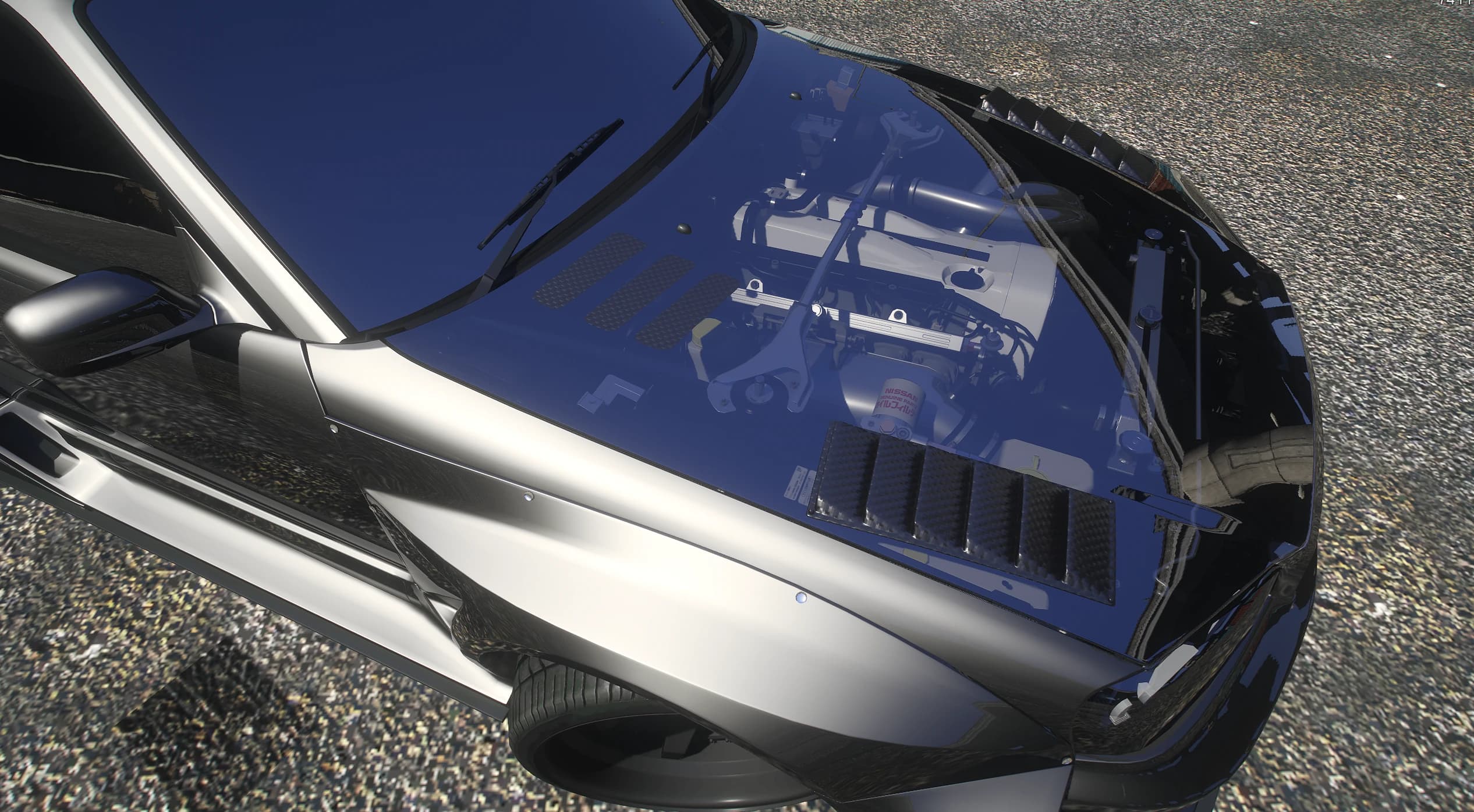 Vista cenital del capó de cristal del R34 mostrando el motor Nissan RB de seis en línea modelado debajo
