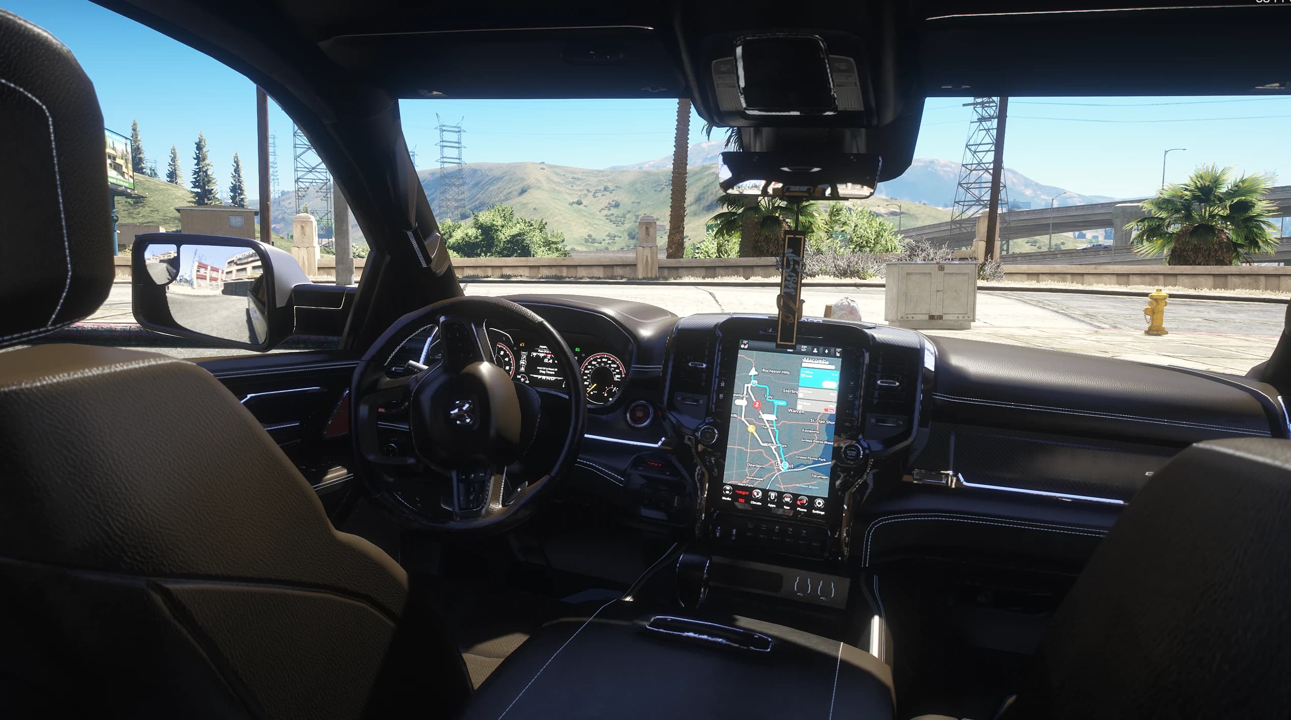 Interior de cuero con la pantalla vertical mostrando el navegador, el cuadro digital y el logo RAM en el volante