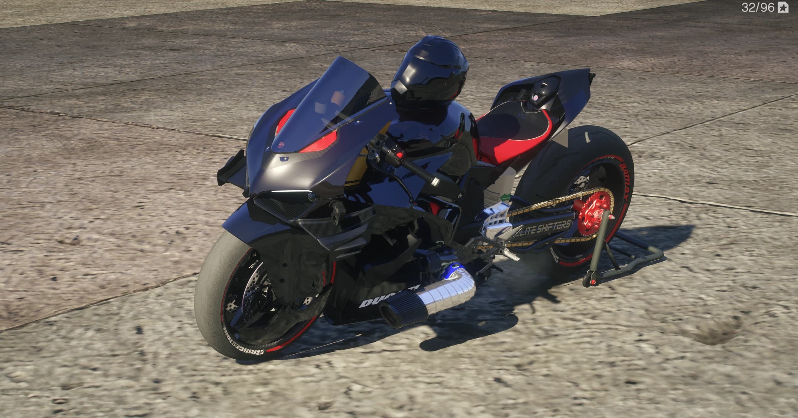 Vista frontal en tres cuartos de la Ducati V4 de drag negra con acentos rojos en el frontal, basculante alargado Elite Shifters, cadena dorada y tubo cromado