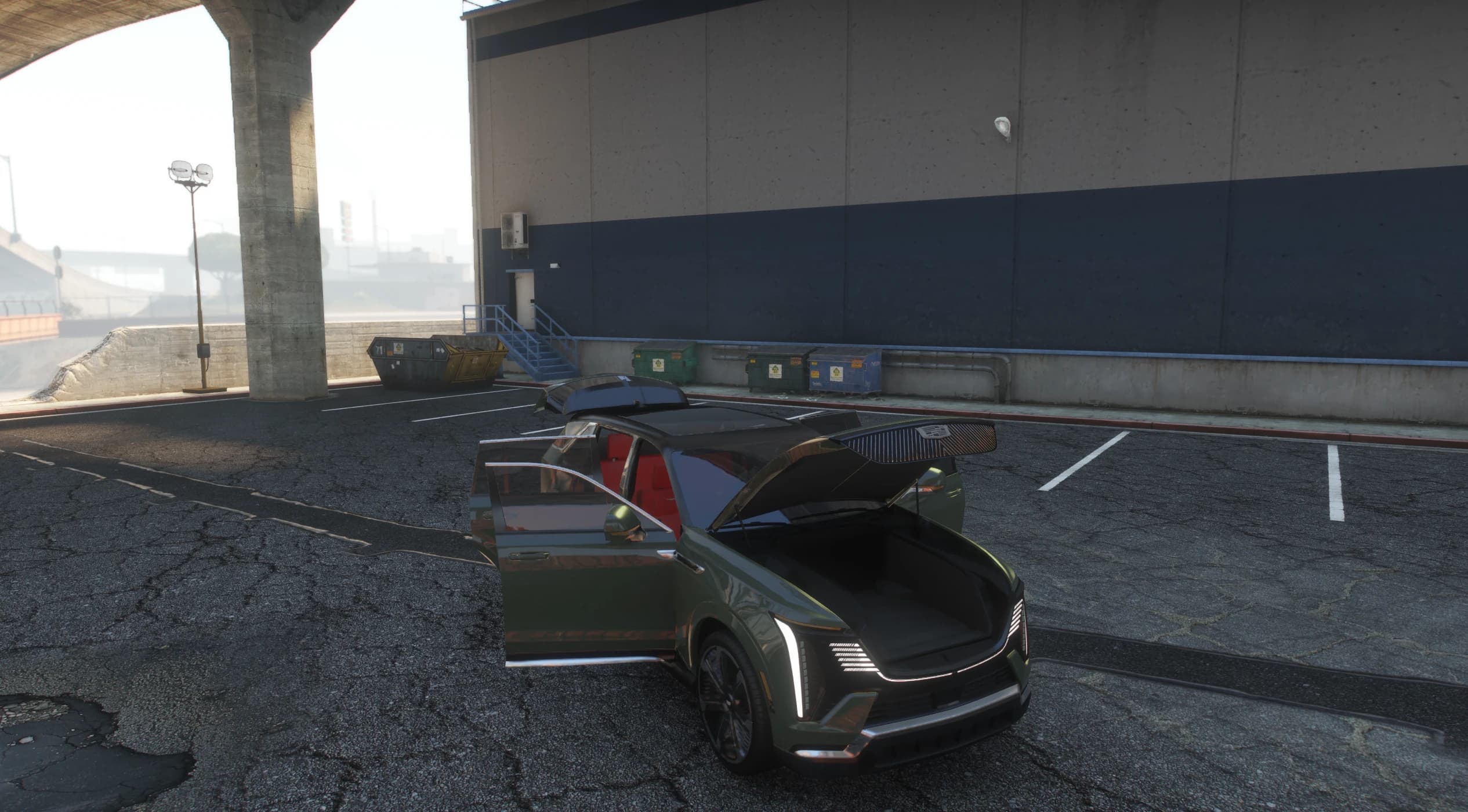 Escalade IQ verde oscuro con la puerta del conductor abierta y el capó eléctrico levantado sobre el maletero delantero, con cuero rojo dentro
