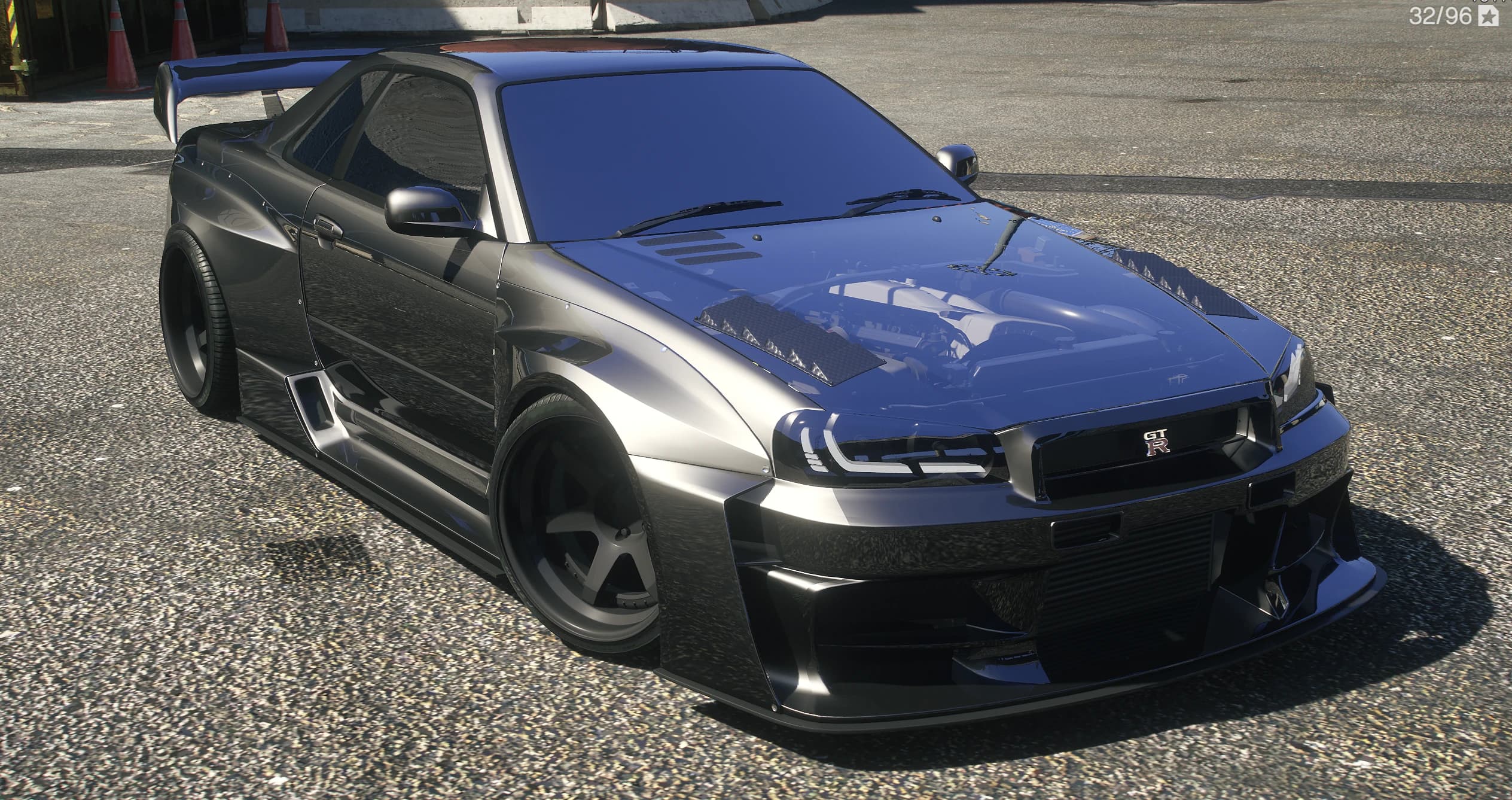 Frontal en tres cuartos del Skyline R34 GT-R ensanchado con el motor a la vista bajo un capó de cristal y un splitter profundo