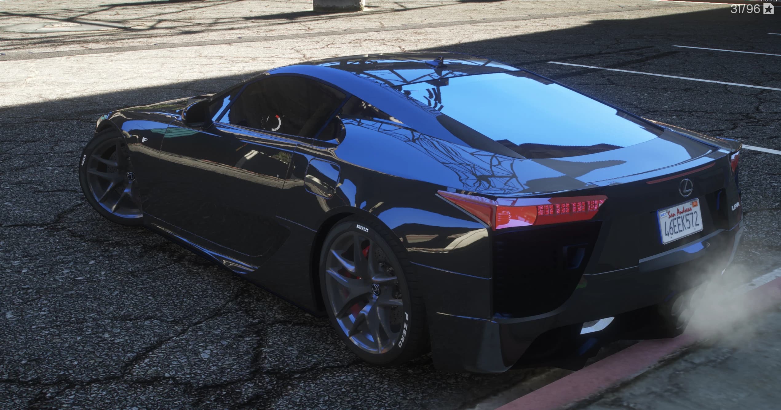 Vista trasera en tres cuartos del LFA negro con el alerón activo recogido, pilotos rojos y neumáticos con letras P Zero