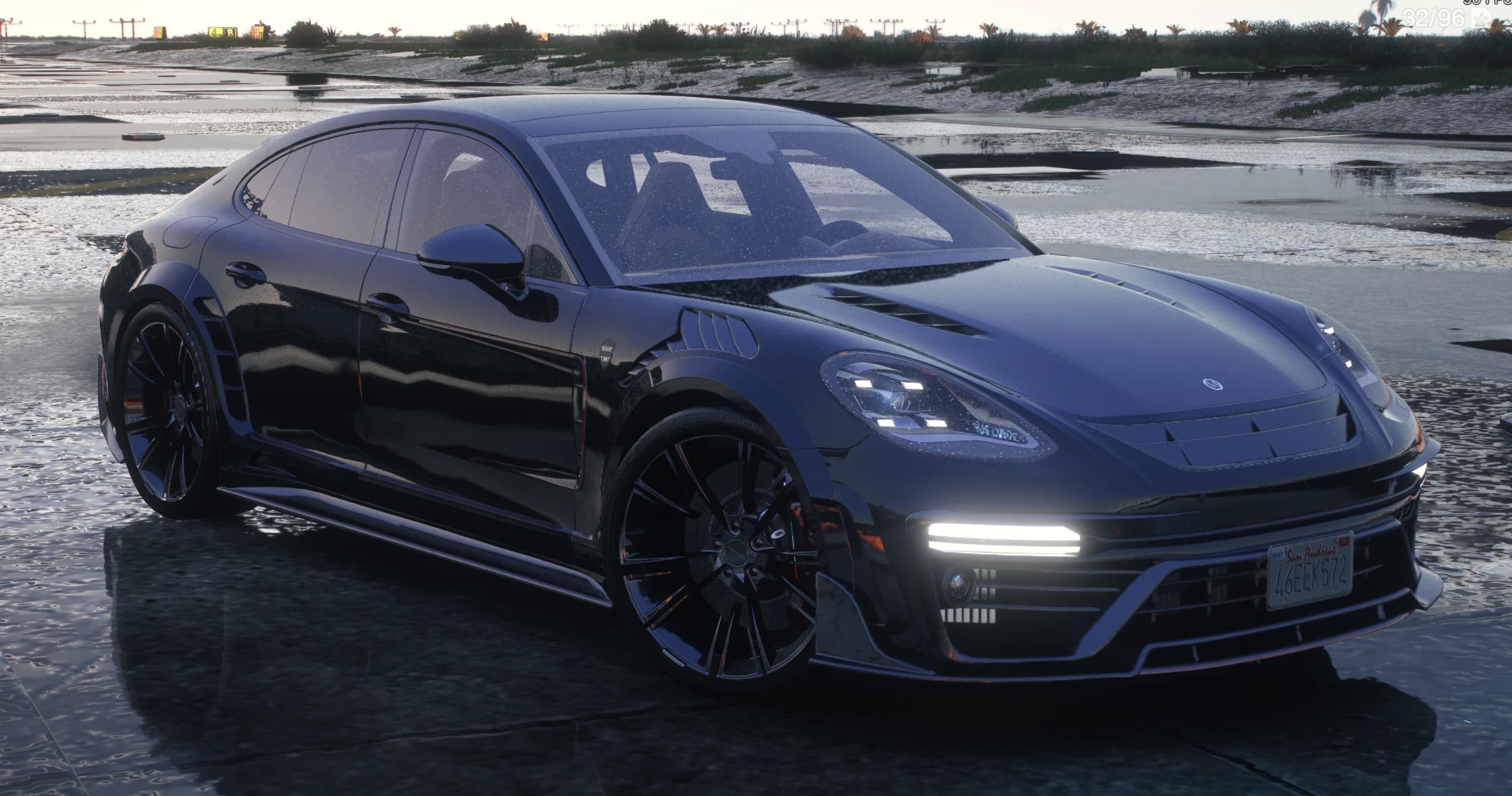 Vista frontal en tres cuartos del Panamera Mansory negro sobre asfalto mojado con capó ventilado, aletas con lamas y tiras LED encendidas en el paragolpes