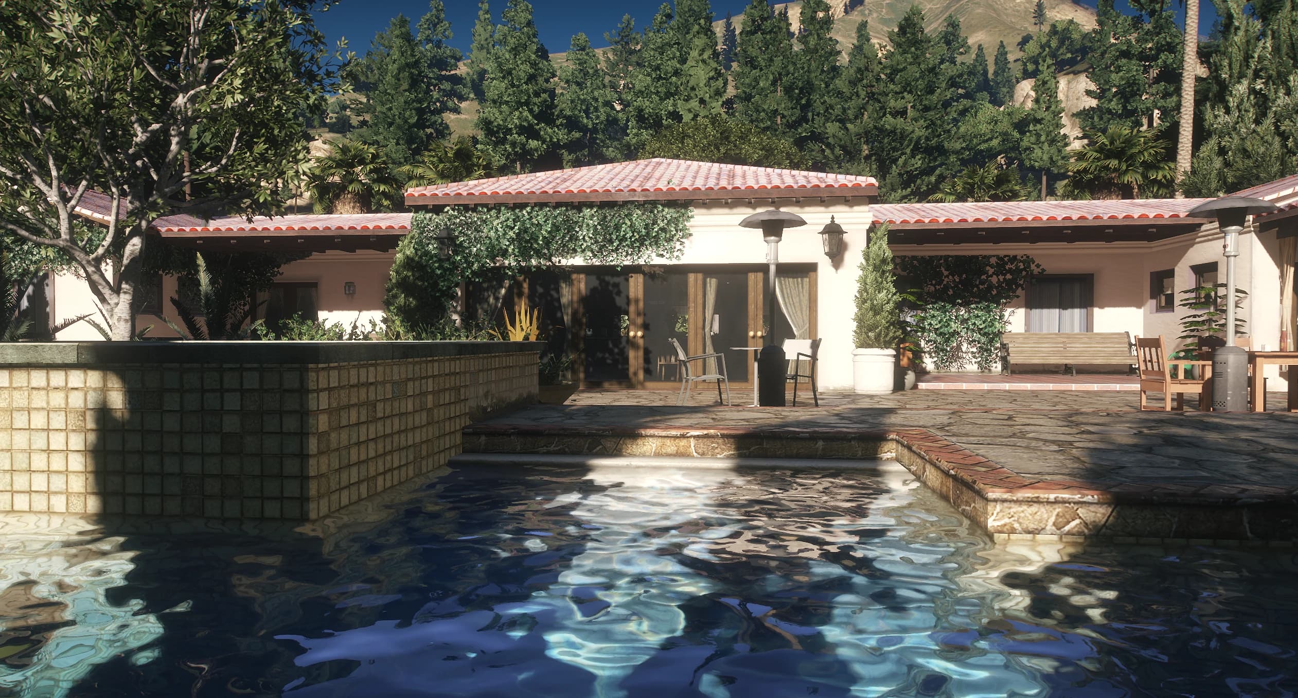 Terraza de la piscina con la casita cubierta de hiedra y el mobiliario de exterior