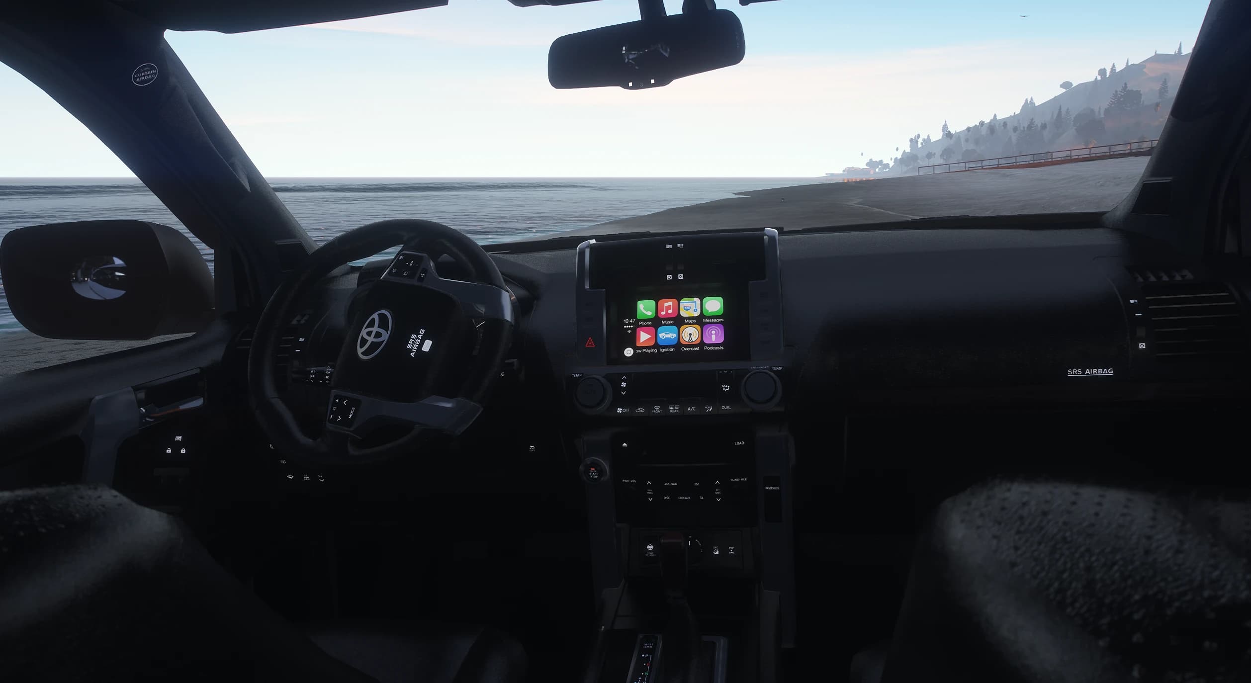 Interior del Prado con el volante Toyota y la pantalla central mostrando un menú tipo CarPlay