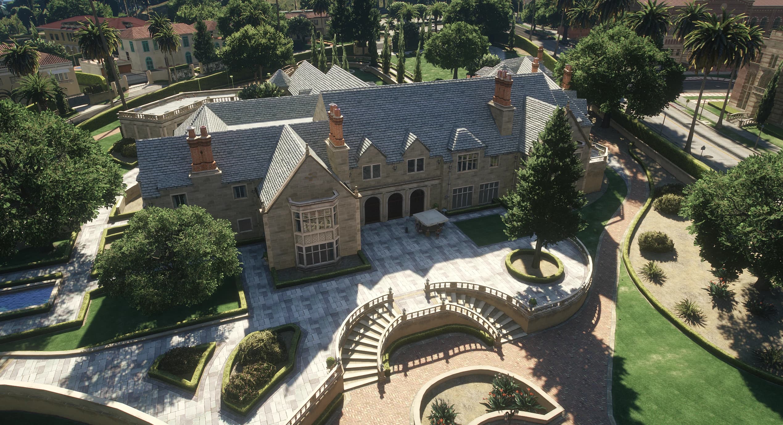 Vista aérea de la finca con la mansión de estilo Tudor, los jardines y las escalinatas curvas
