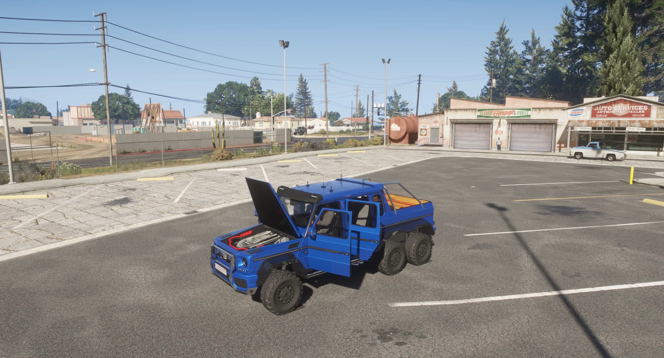 El G63 6x6 con el capó y la puerta abiertos en un aparcamiento, dejando ver la bahía del motor modelada