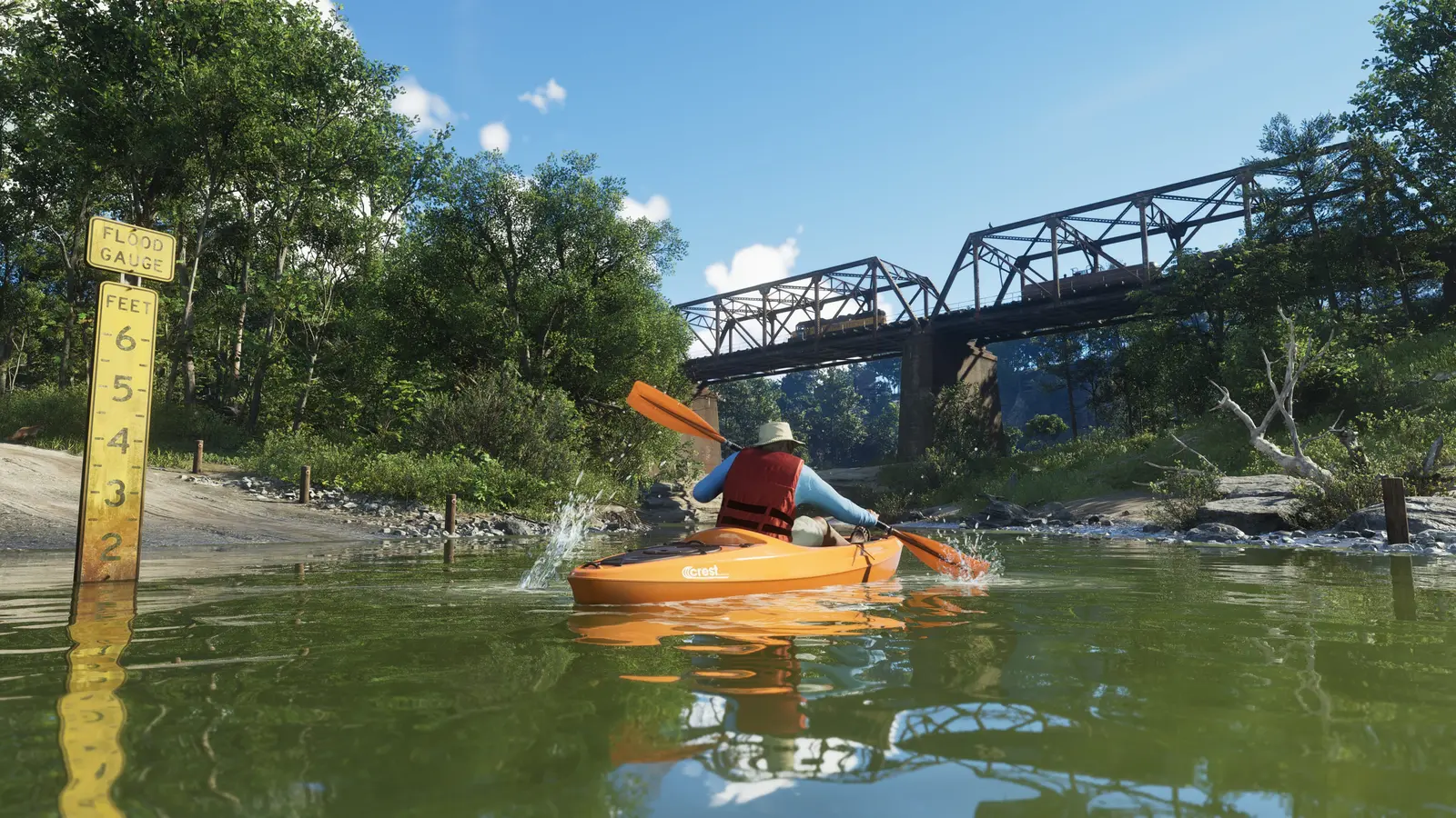 Un jugador remando en un kayak naranja por un río del Parque Nacional Mount Kalaga, junto a un poste medidor del nivel del agua y un puente metálico al fondo